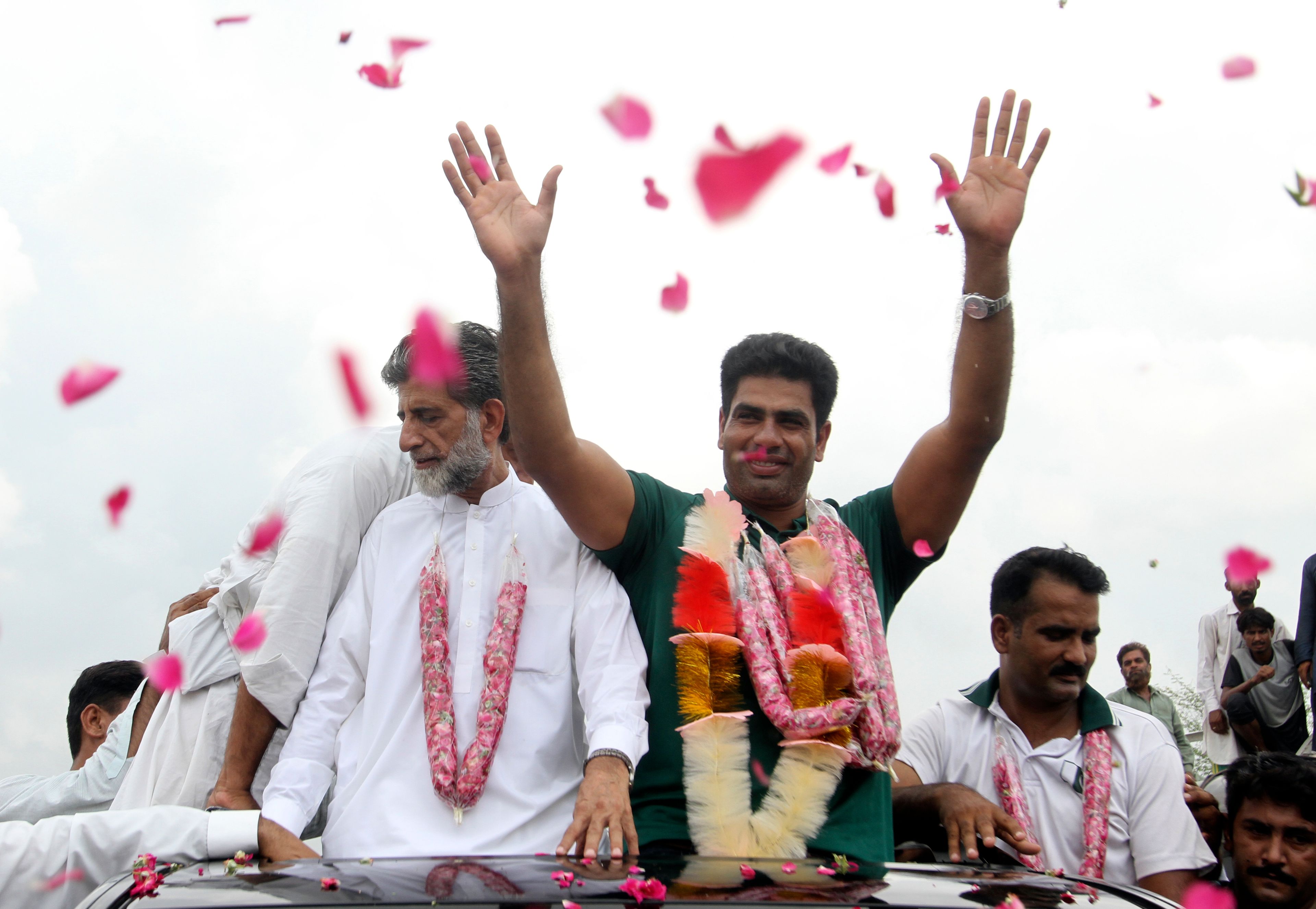 Men's javelin gold medalist, Arshad Nadeem of Pakistan, centre, waves to people outside his village in Mian Channu, Khanewal district, of Pakistan, Sunday, Aug. 11, 2024. (AP Photo/Asim Tanveer)