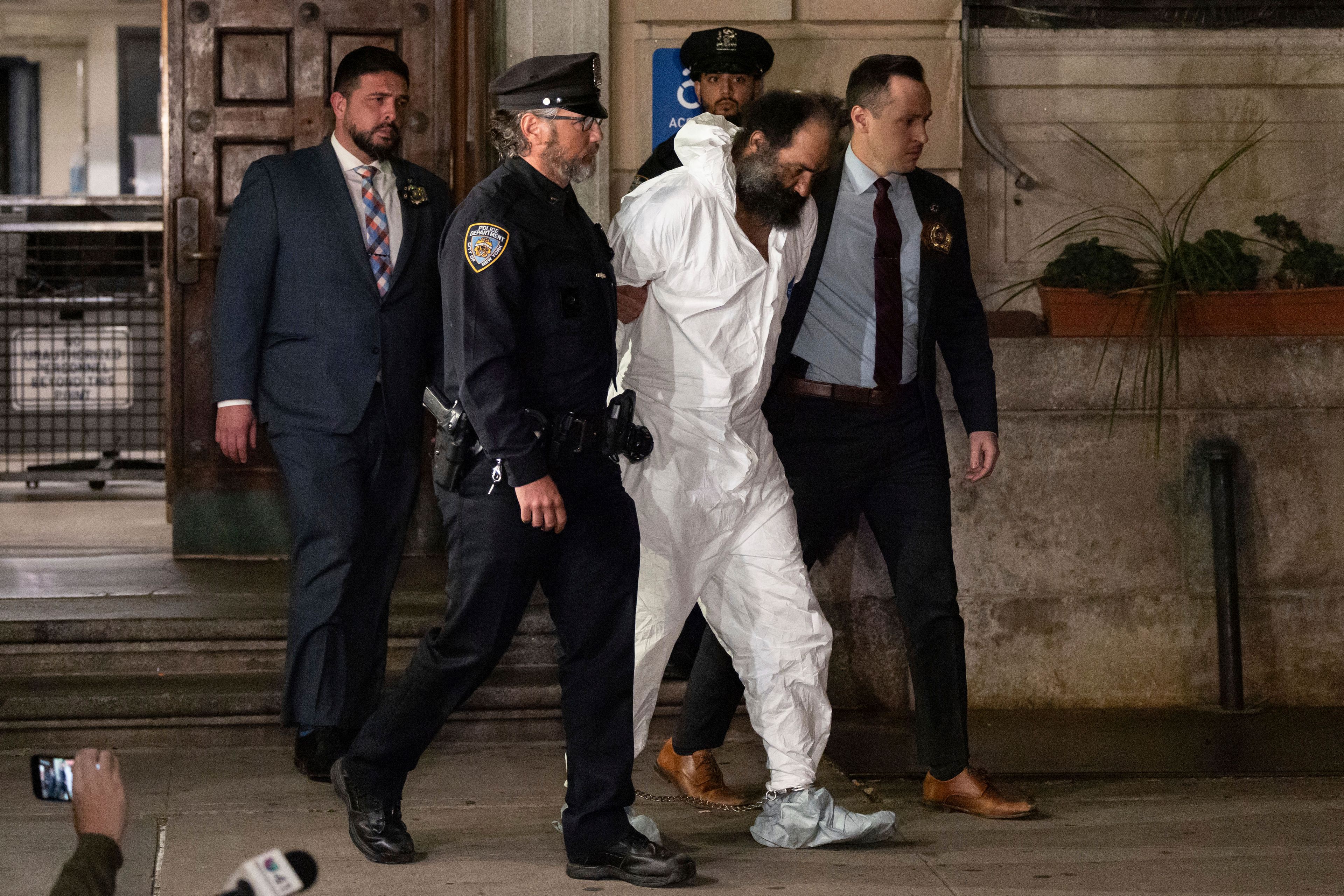 Ramon Rivera, a suspect arrested after multiple people were stabbed early Monday, is escorted out by NYPD officers at the NYPD 10th Precinct in New York, Monday, Nov. 18, 2024. (AP Photo/Yuki Iwamura)