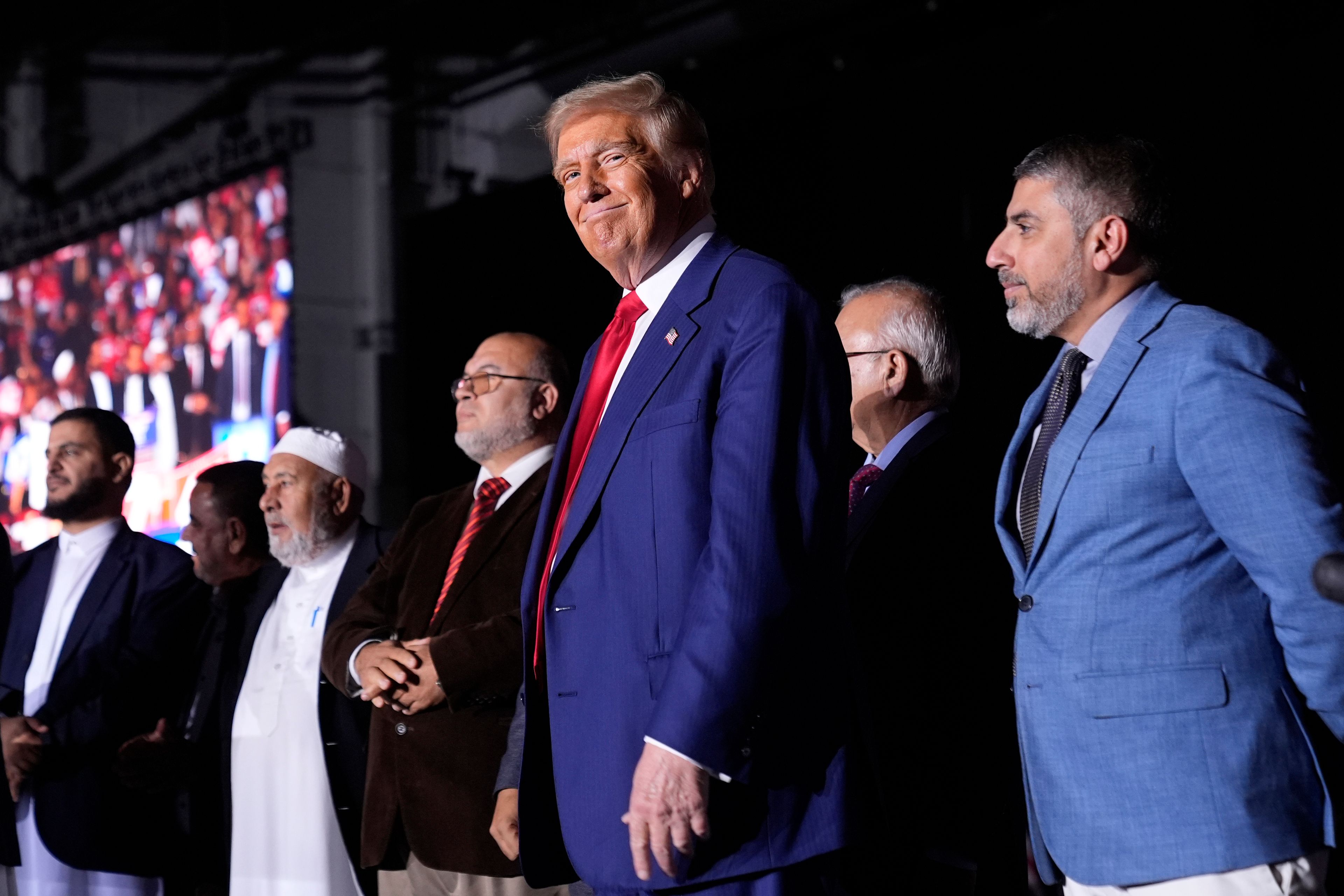 Republican presidential nominee former President Donald Trump, center, stands alongside local Muslim leaders during a campaign rally at the Suburban Collection Showplace, Saturday, Oct. 26, 2024, in Novi, Mich. (AP Photo/Alex Brandon)