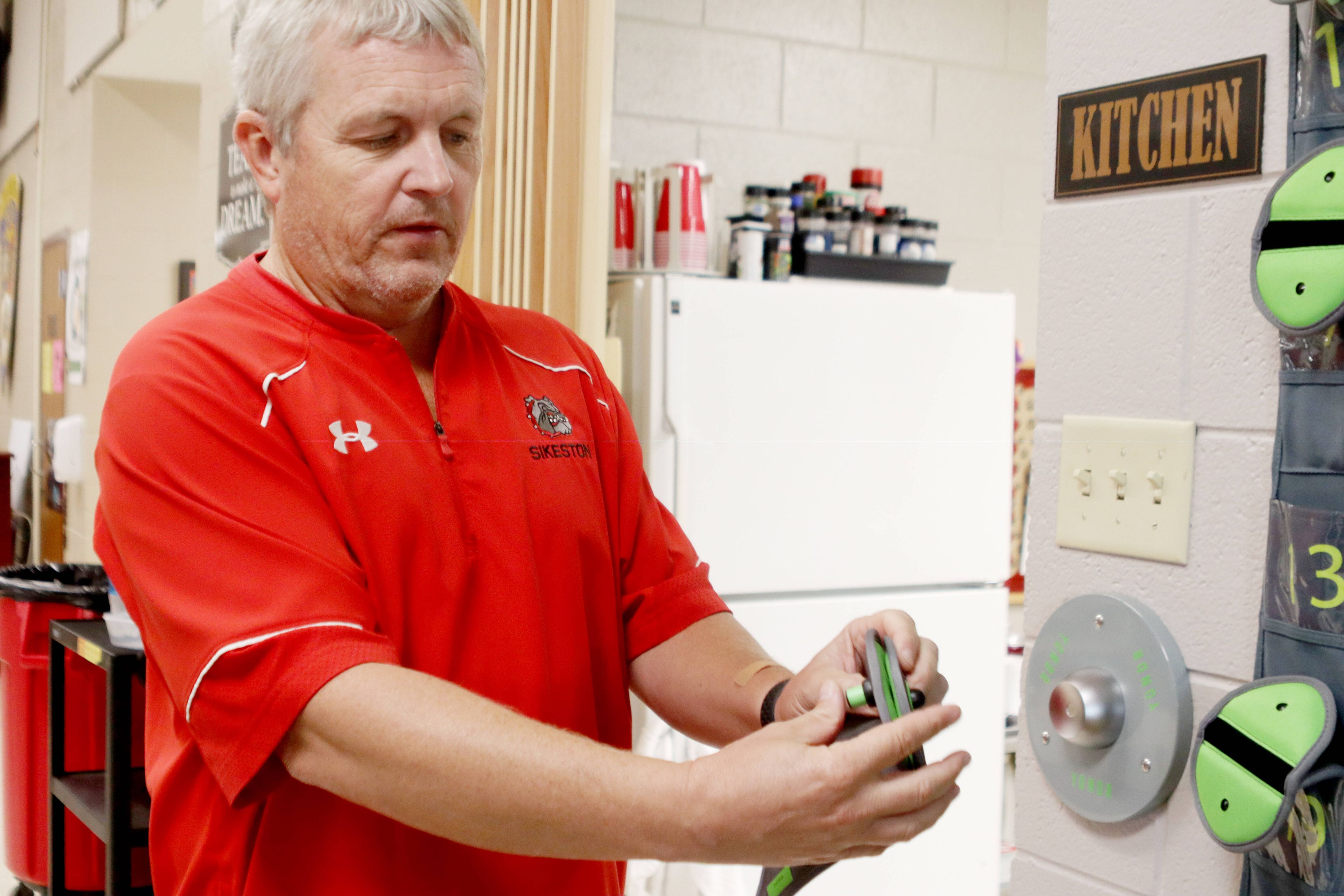 Sikeston Alternative Education Center Principal Brian James demonstrates how the Yondr cell phone pouches work Friday, Aug. 23, at the school.
