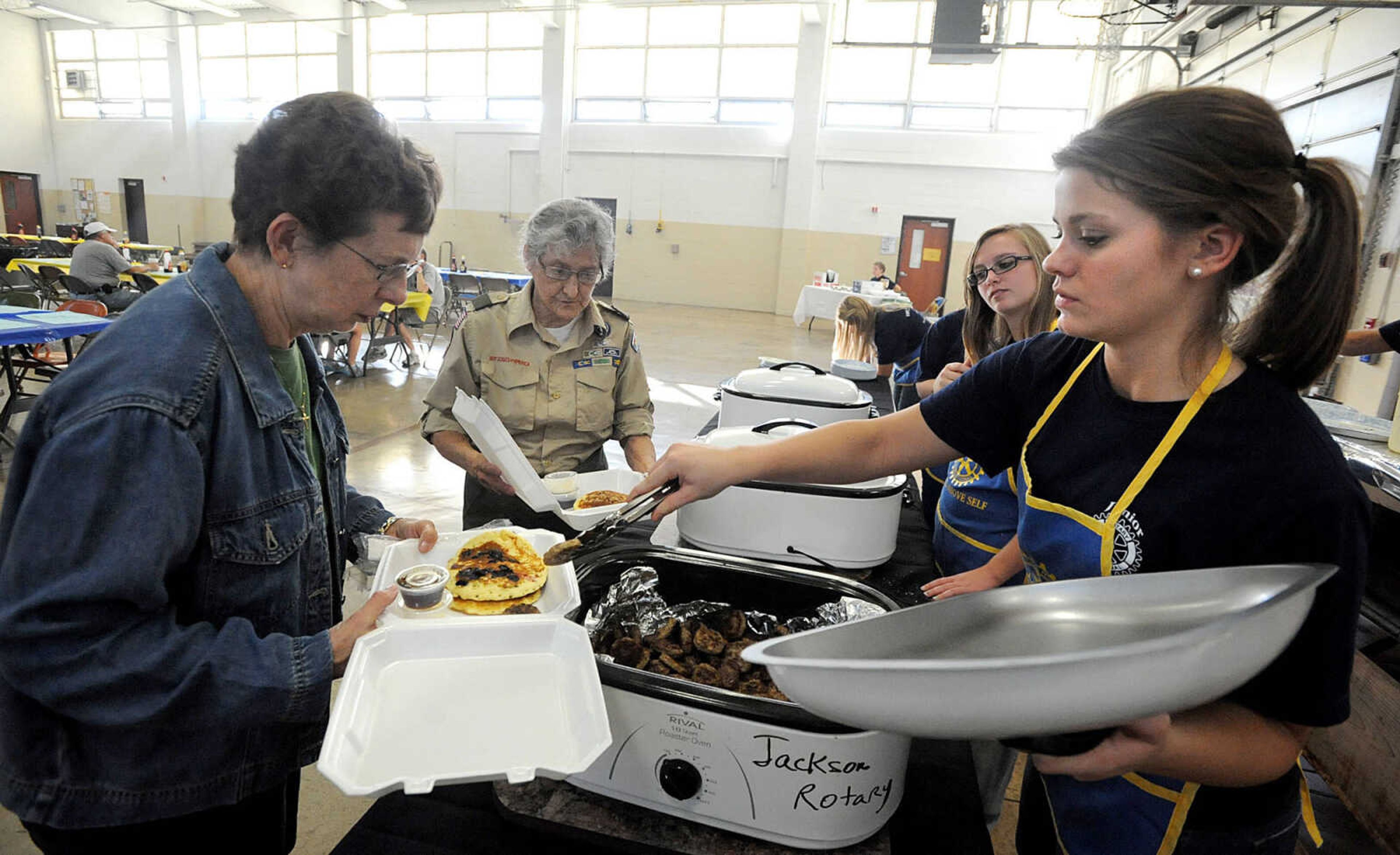 LAURA SIMON ~ lsimon@semissourian.com
Junior Rotarian Emma Steffens places pancakes Sheila Kaiser's carryout box as Kaiser and Patty Johnson go through the line Tuesday, Oct. 23, 2012 during the Jackson Rotary Pancake Day at the National Guard Armory. People could pick from plain, chocolate chip, pecan and blueberry pancakes and a side of sausage.