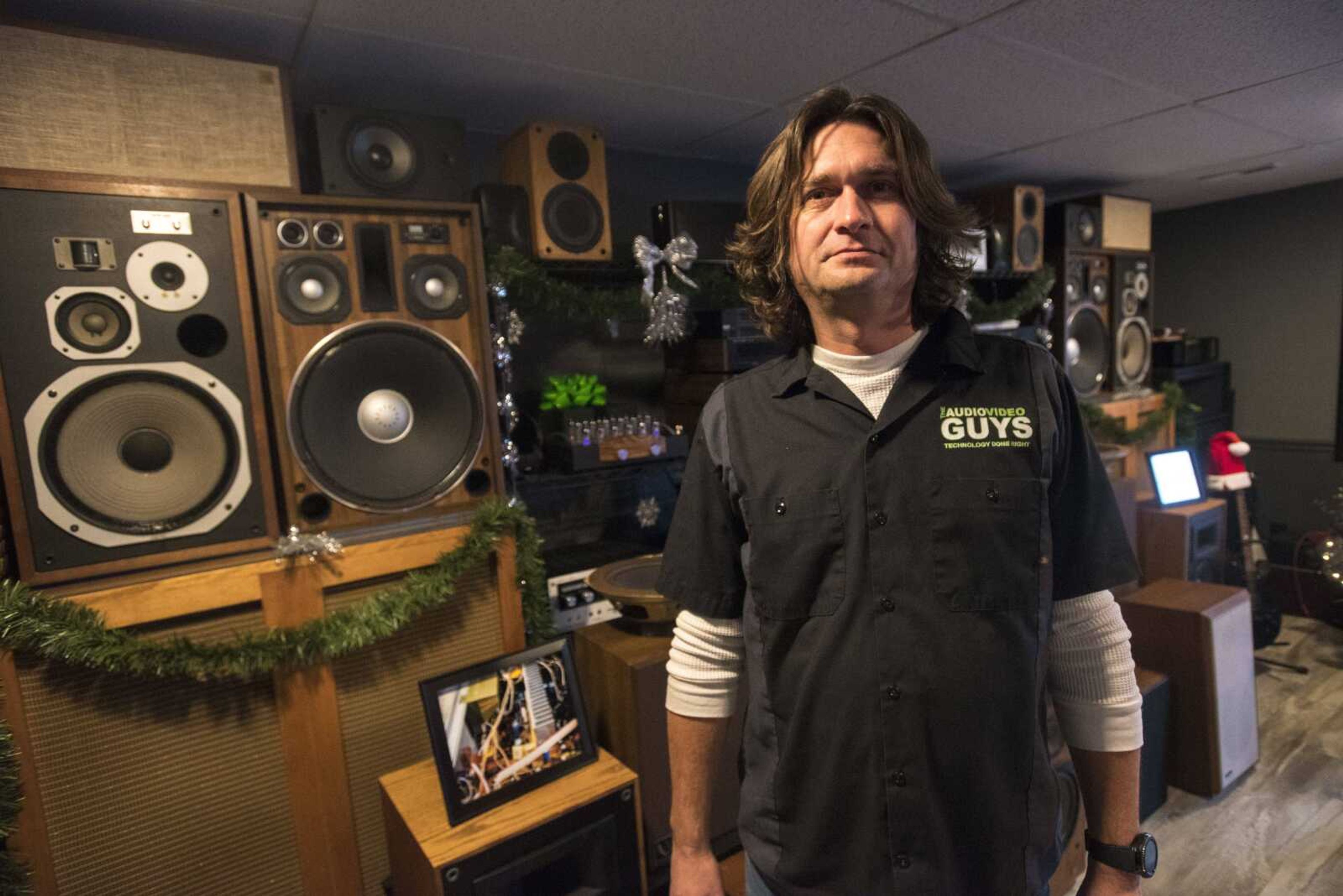 Brett Smith, owner of The Audio Video Guys, poses for a photo in front of a collection of his speakers and turntables at his business Thursday in Jackson.