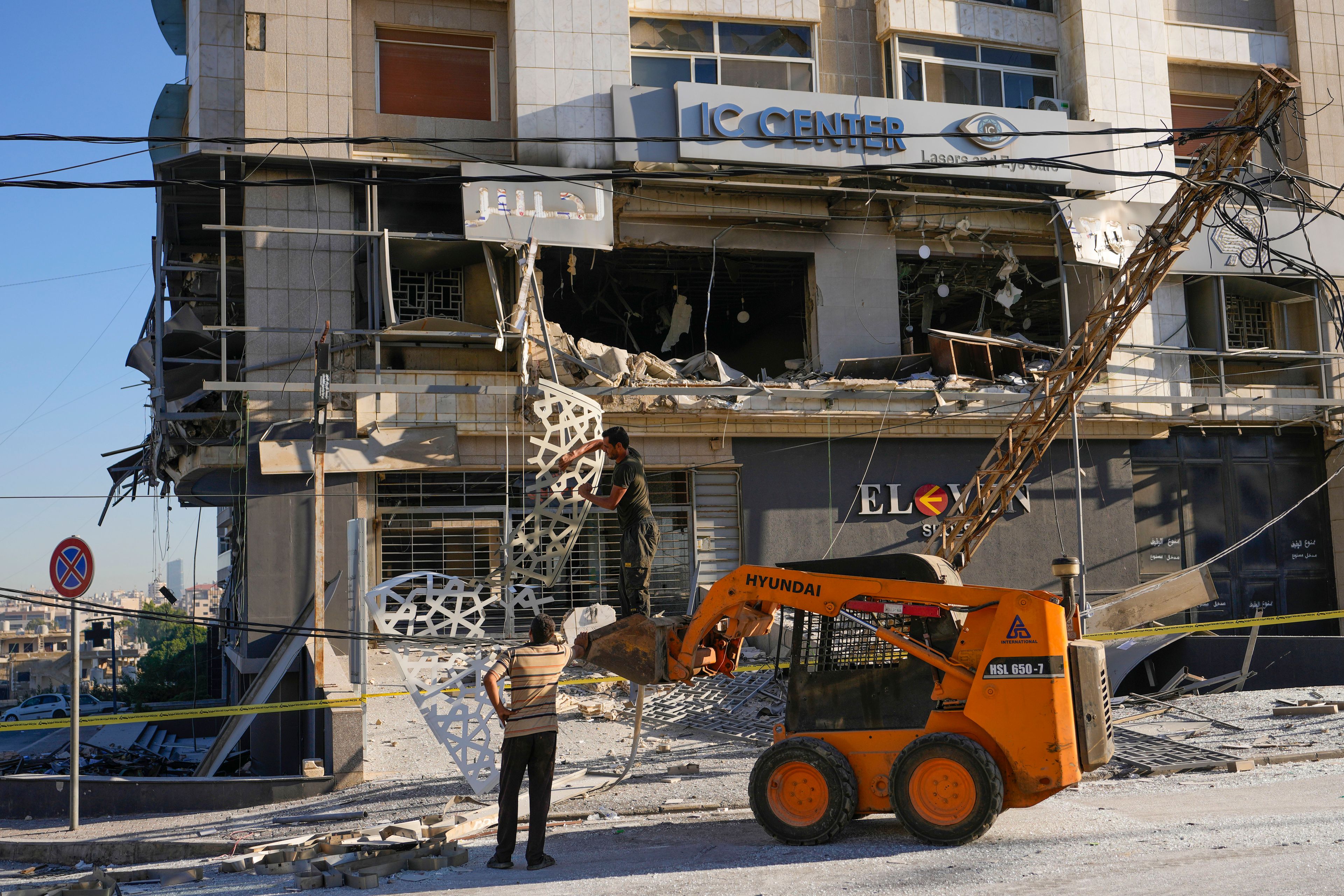 Rescue workers use a skid loader to remove rubble at the site of an Israeli airstrike that hit several branches of the Hezbollah-run al-Qard al-Hassan in Dahiyeh, Beirut, Lebanon, Monday, Oct. 21, 2024. (AP Photo/Hassan Ammar)