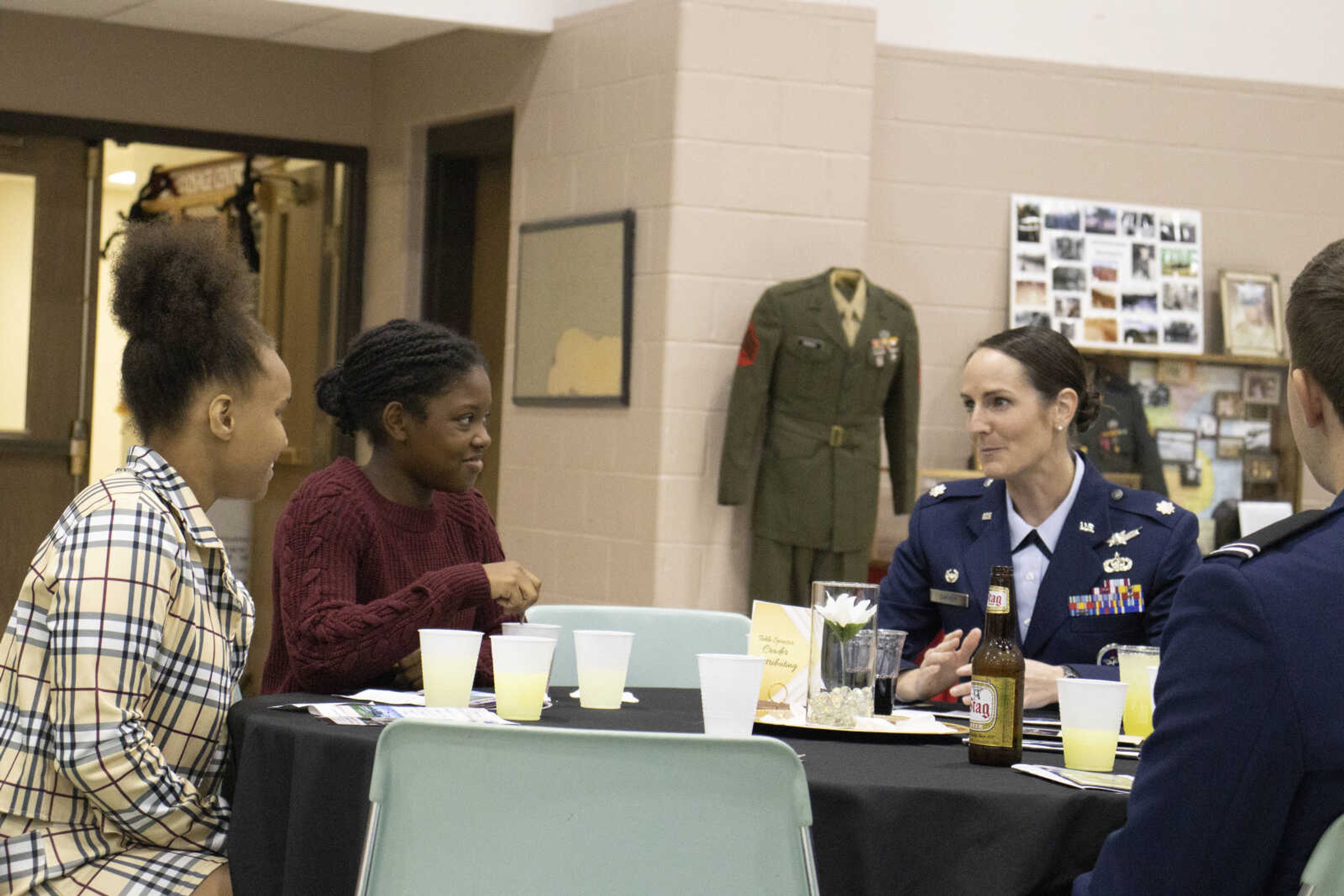 Lieutenant Colonel Jessica Dwyer talks to two girls while at their dinner table at the Sprit of Democracy dinner.