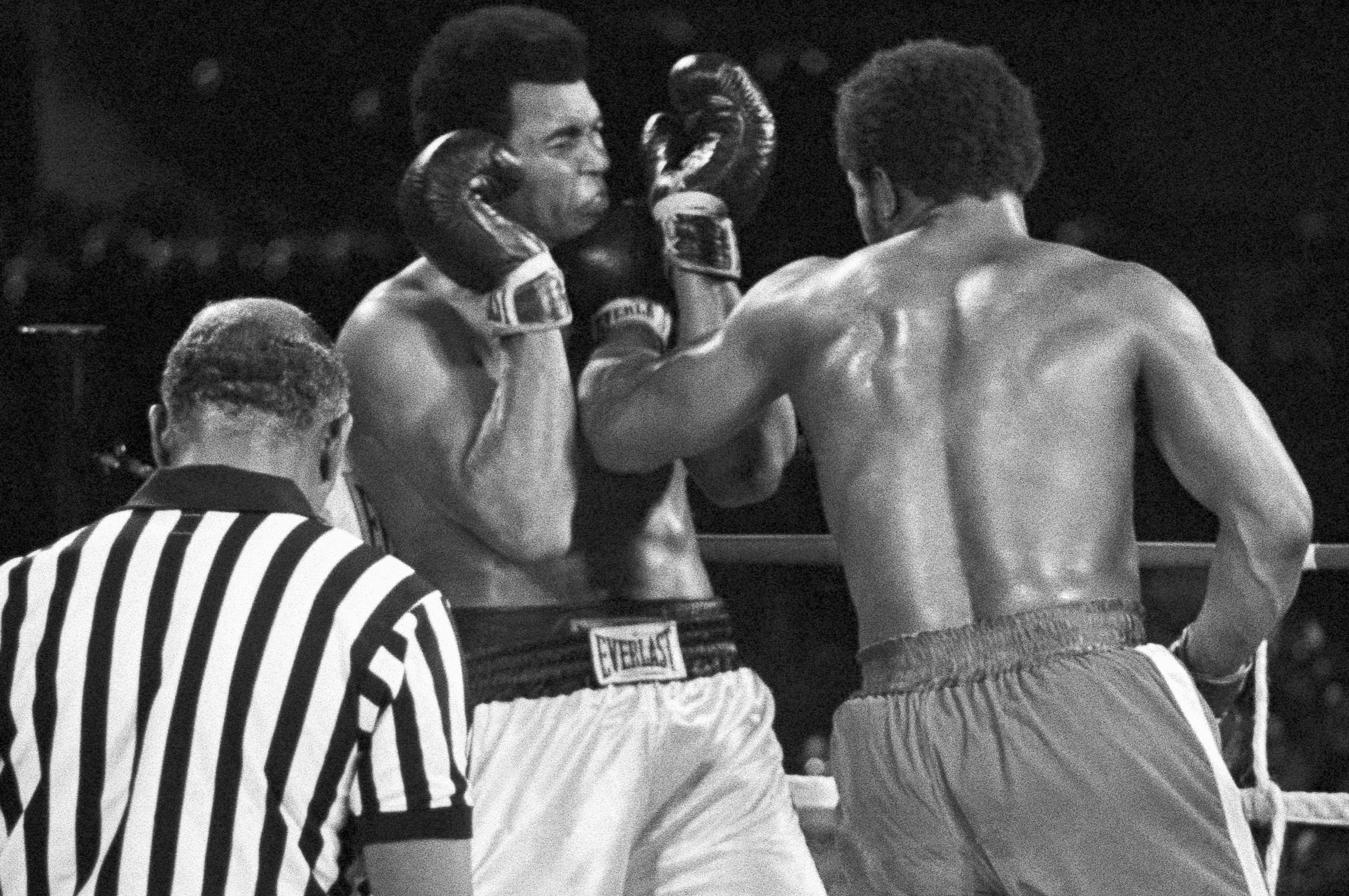 FILE - Muhammad Ali winces as he takes a George Foreman left to the jaw in fifth round of their heavyweight championship bout in Kinshasa, Zaire, on Oct. 30, 1974. (AP Photo/Ed Kolenovsky, File)