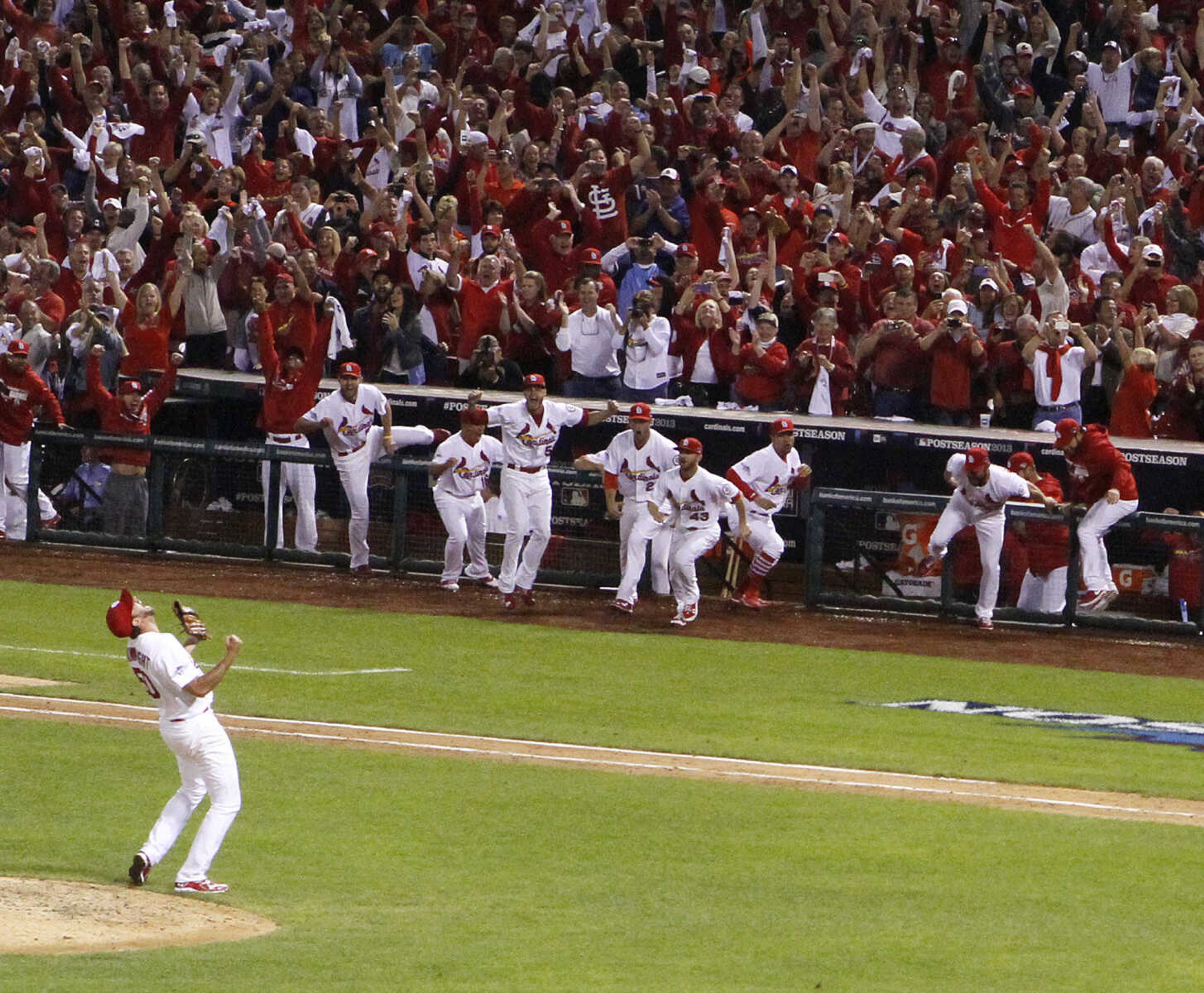 St. Louis Cardinals starting pitcher Adam Wainwright celebrates his complete game victory as teammates rush the field after Game 5 of the National League Division Series between the St. Louis Cardinals and the Pittsburgh Pirates on Wednesday, Oct. 9, 2013, at Busch Stadium in St. Louis.   (AP Photo/post-dispatch.com, Chris Lee)