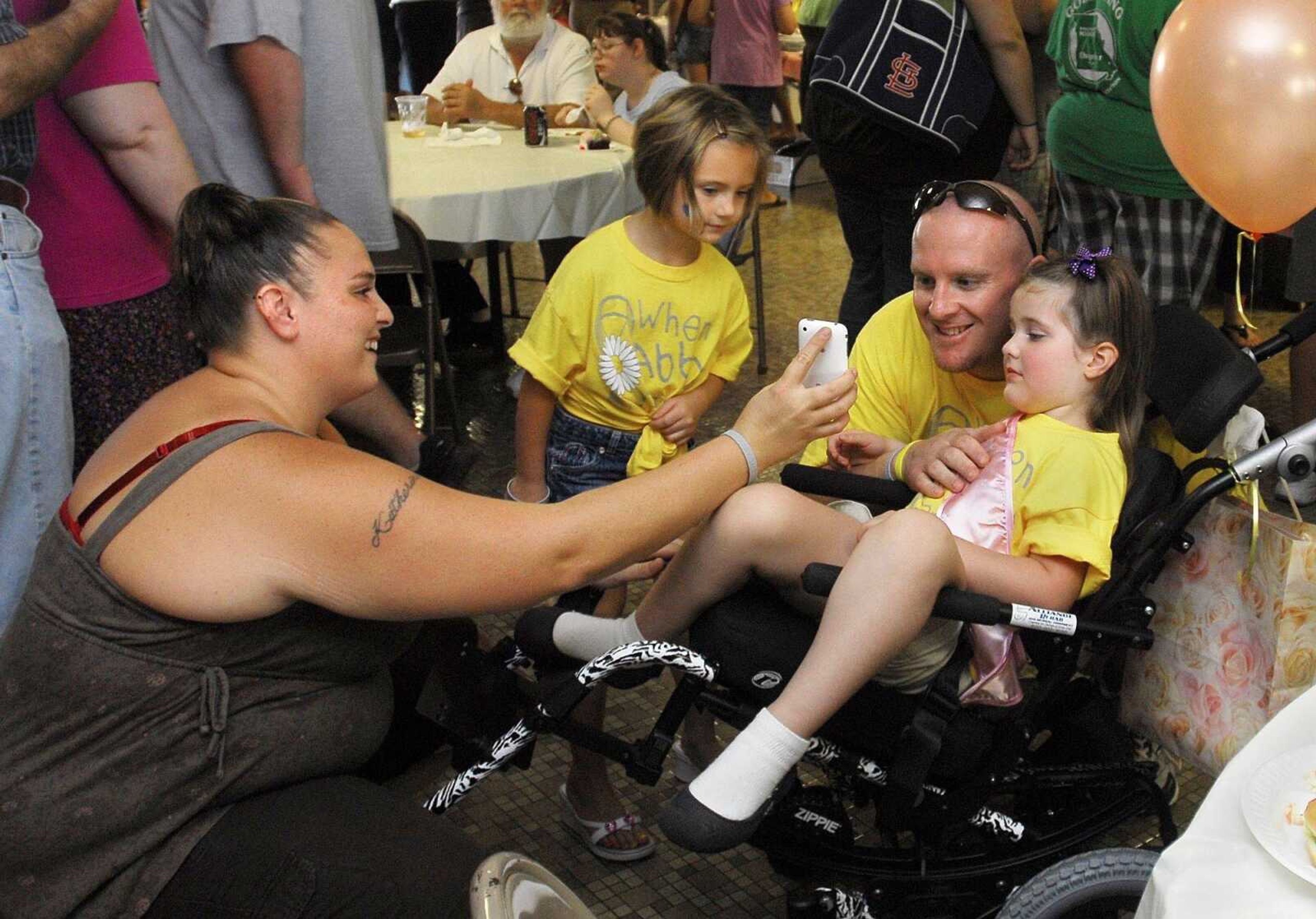 Shannon Cook shows Jon Jensen and his daughter Abby, 4, the photo she took of them Sunday as Madison Bhanom, 5, takes a peek from the side. (Laura Simon)