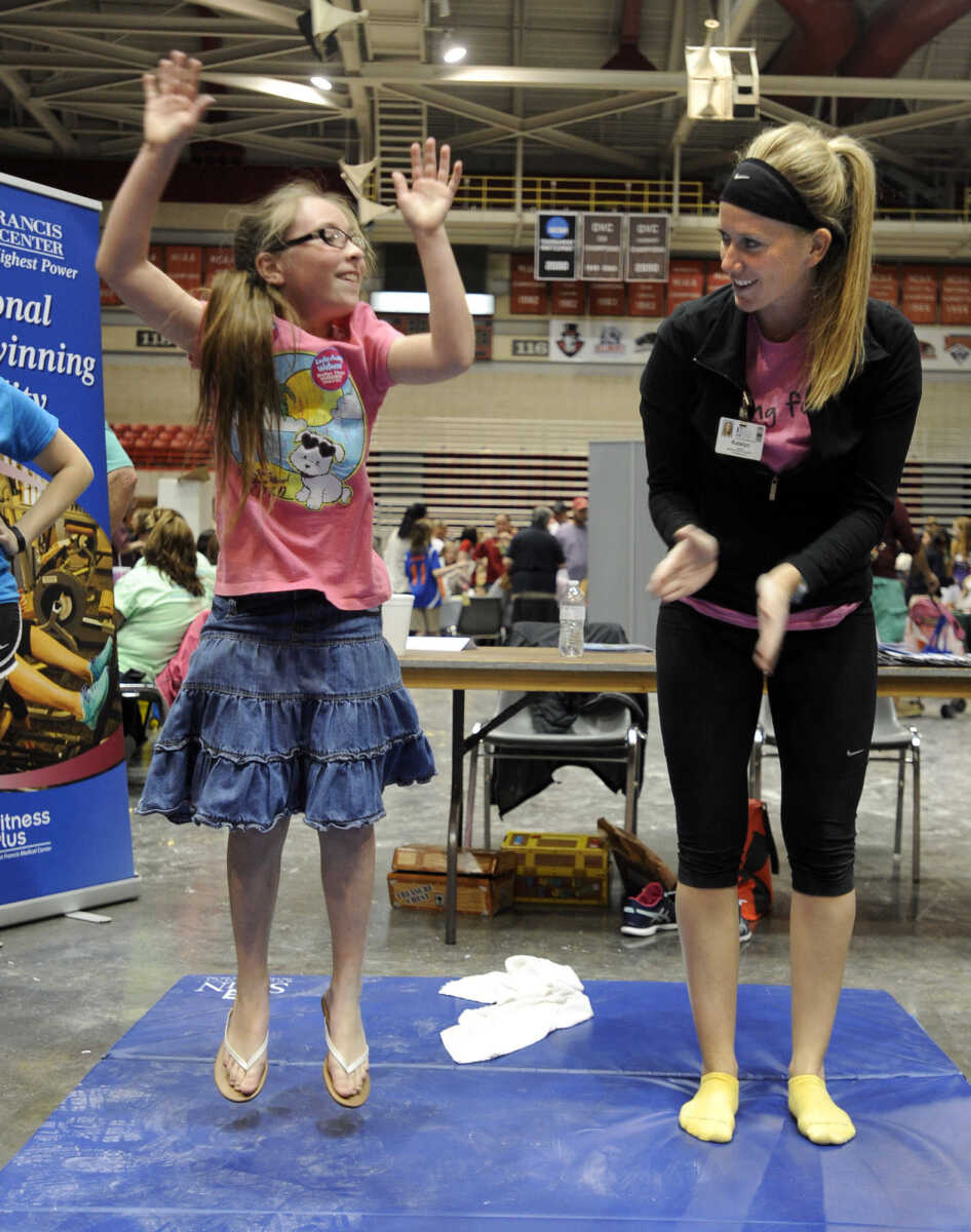 Jadyn Coleman of Jackson performs a burpee with encouragement from Katelyn Myracle with Saint Francis Fitness Plus at the Messy Morning event Saturday, April 25, 2015 at the Show Me Center.