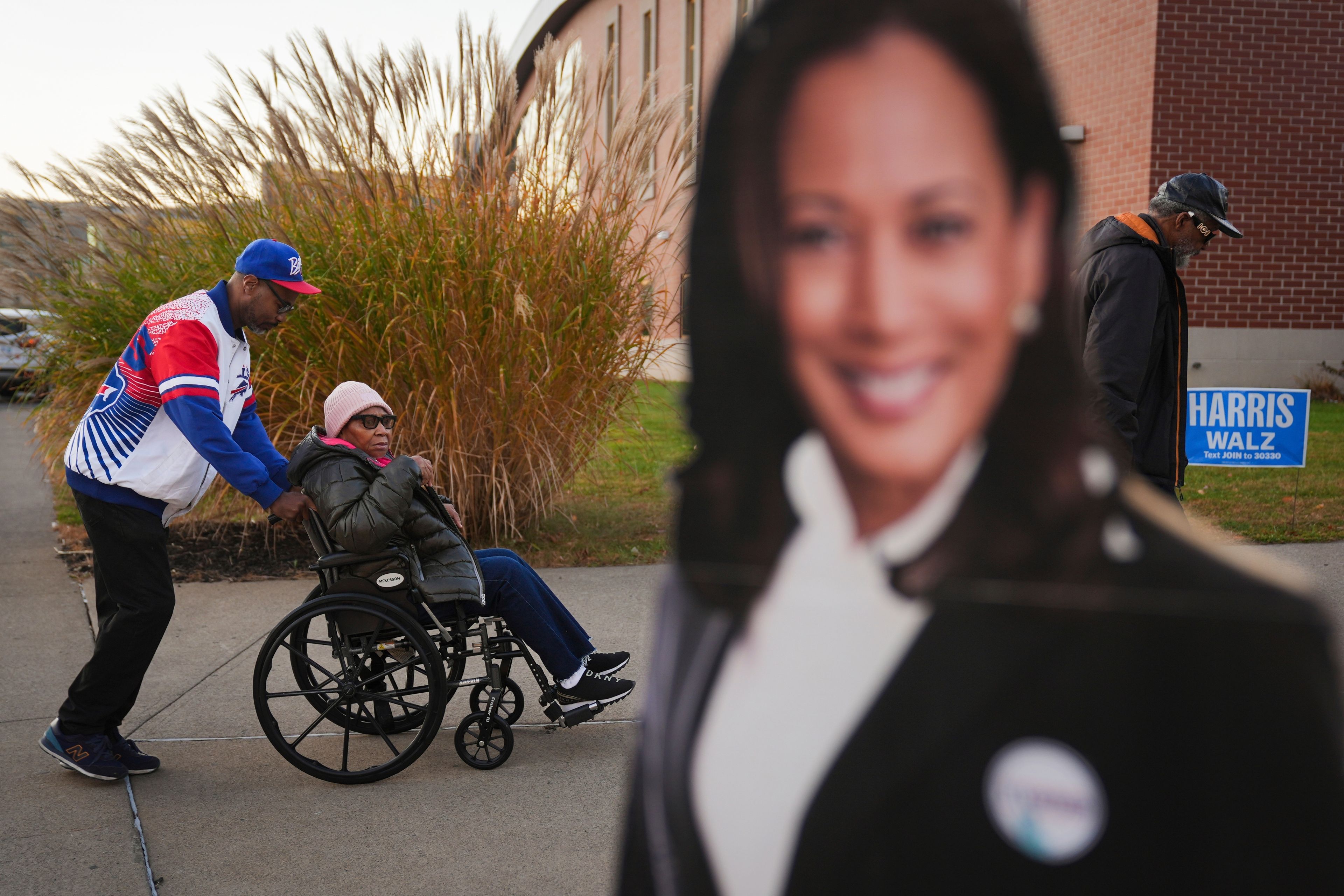 Liza Fortt, 74, center, accompanied by her son Timothy Walker, left, and husband Willie Fortt moves in line to cast her ballot for Democratic presidential nominee Vice President Kamala Harris at a polling place at Scranton High School in Scranton, Pa., on Election Day, Tuesday, Nov. 5, 2024. (AP Photo/Matt Rourke)