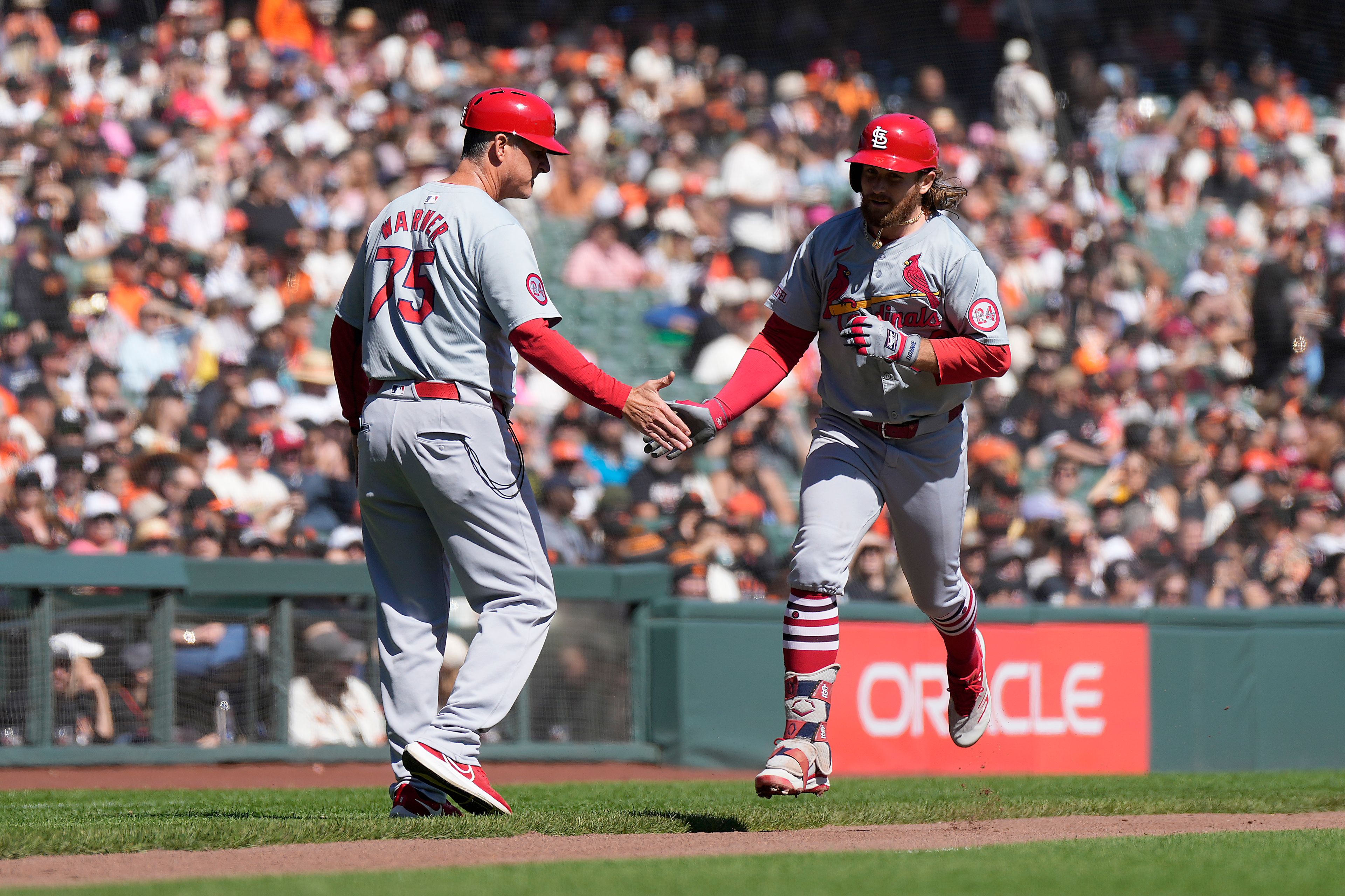 St. Louis Cardinals' Brendan Donovan, right, is congratulated by third base coach Ron Warner (75) as he rounds the bases after hitting a solo home during the third inning of a baseball game against the San Francisco Giats, Sunday, Sept. 29, 2024, in San Francisco. (AP Photo/Tony Avelar)