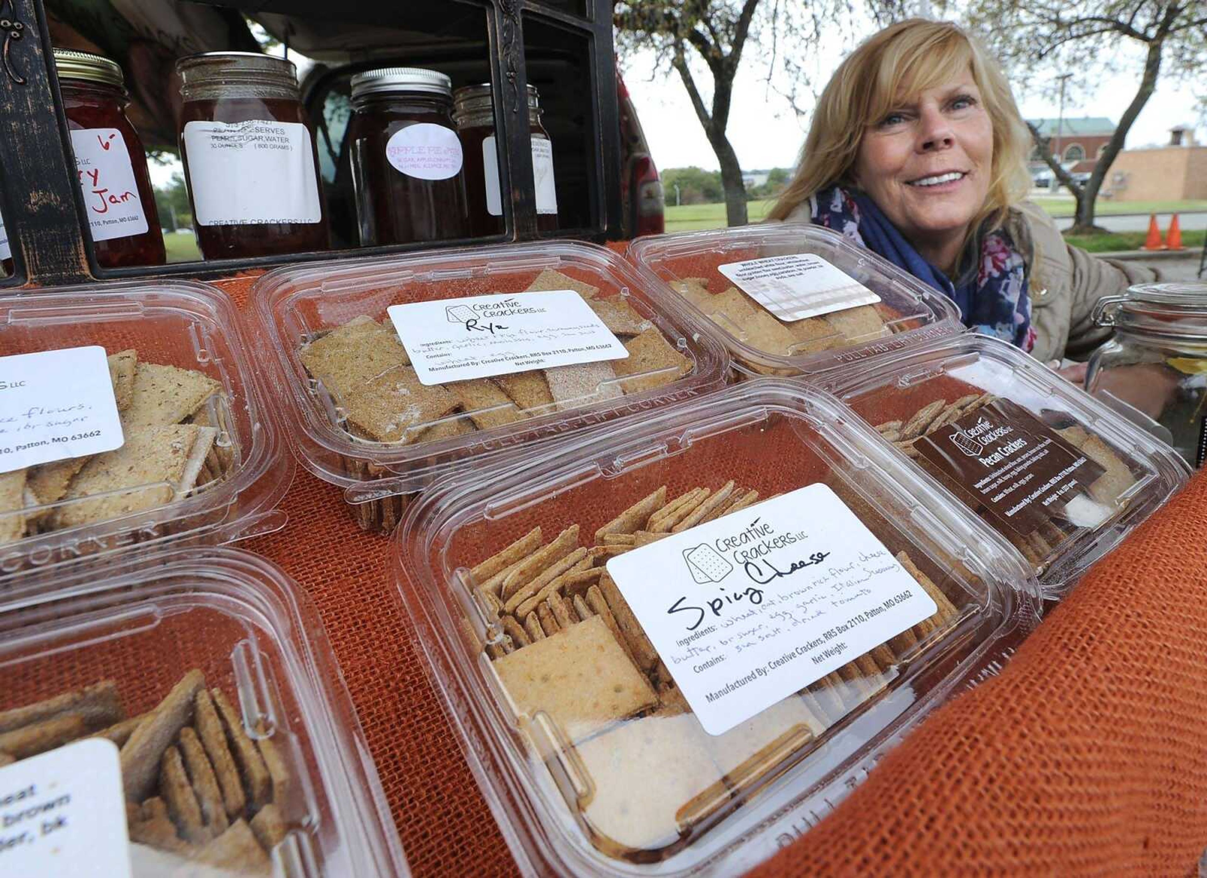 Nancy Mayfield, owner of Creative Crackers LLC, poses for a photo with varieties of home-baked crackers Thursda at the Cape Farmers Market.