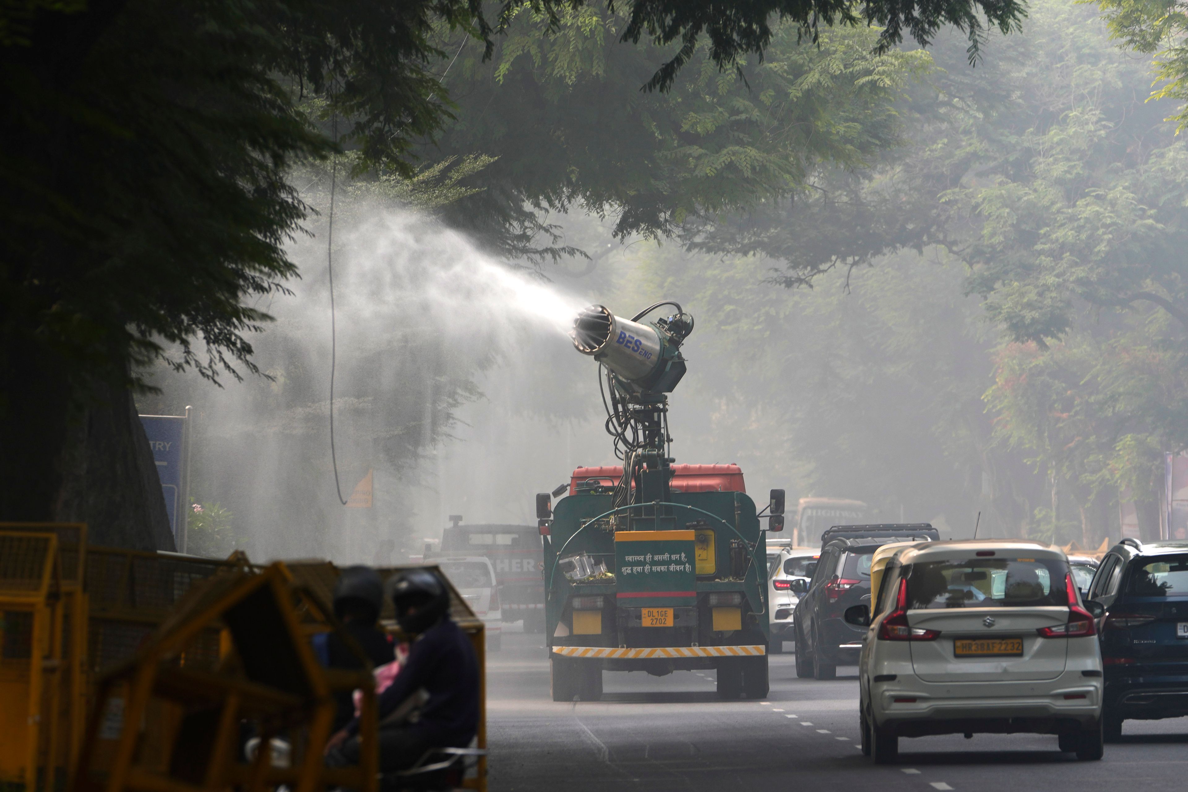 A Delhi government vehicle sprinkles water to control air pollution as a thick layer of smog envelops the city, New Delhi, India, Thursday, Nov. 14, 2024. (AP Photo/Manish Swarup)