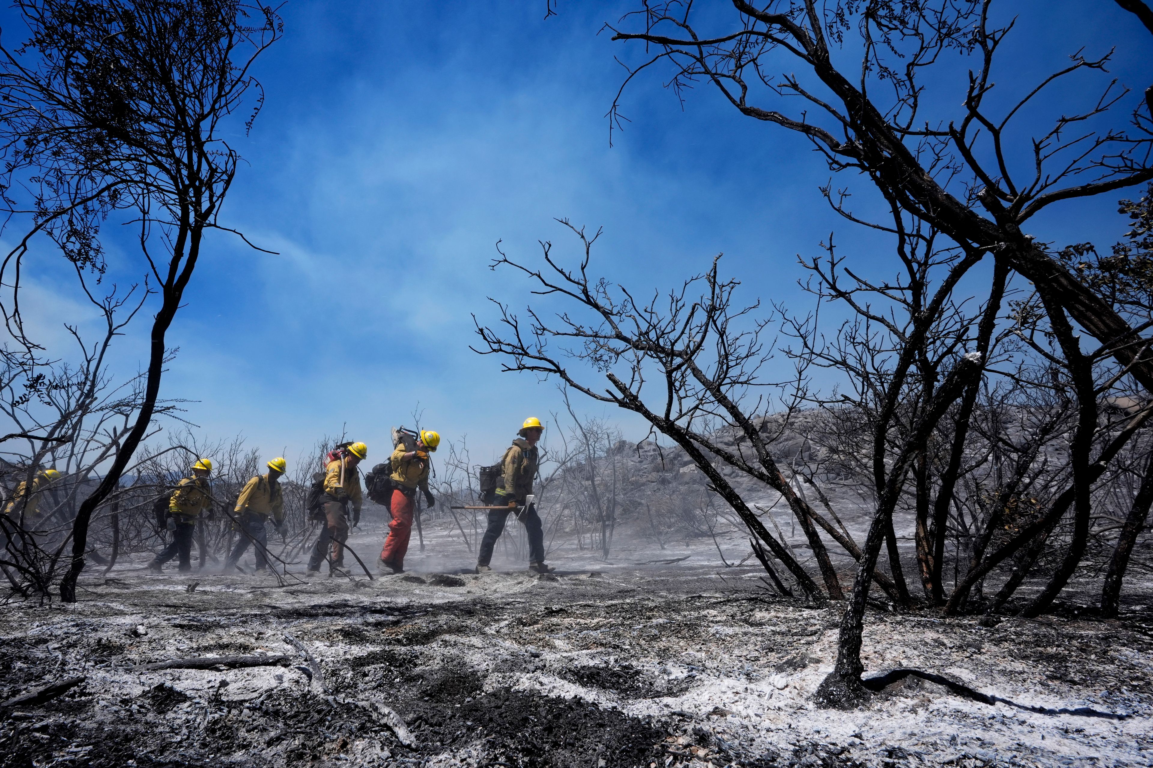 Members of Riverside County Cal Fire monitor for hot spots while battling the Airport Fire Wednesday, Sept. 11, 2024, in El Cariso Village, in unincorporated Riverside, County, Calif. (AP Photo/Gregory Bull)