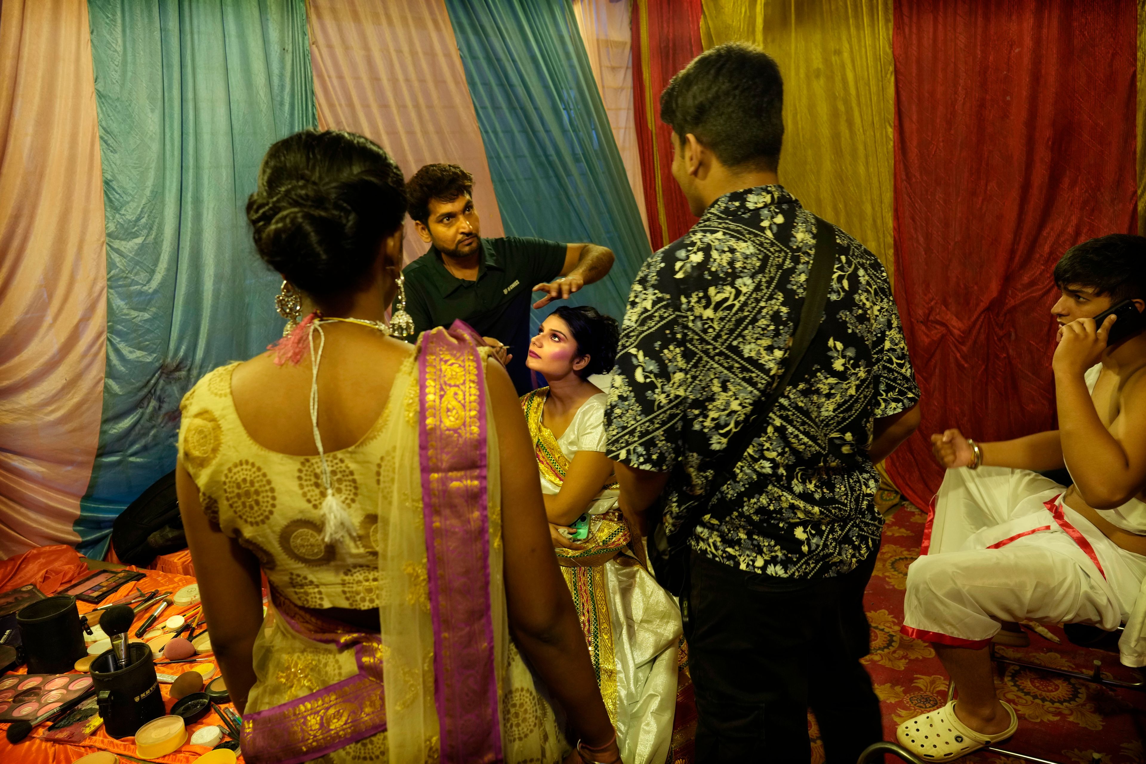 Hitanshi Jha, 21, center, playing the character of Hindu god Rama's wife Sita, gets ready backstage for Ramleela, a dramatic folk re-enactment of the life of Rama according to the ancient Hindu epic Ramayana, in New Delhi, India, Saturday, Oct. 5, 2024. (AP Photo/Manish Swarup)