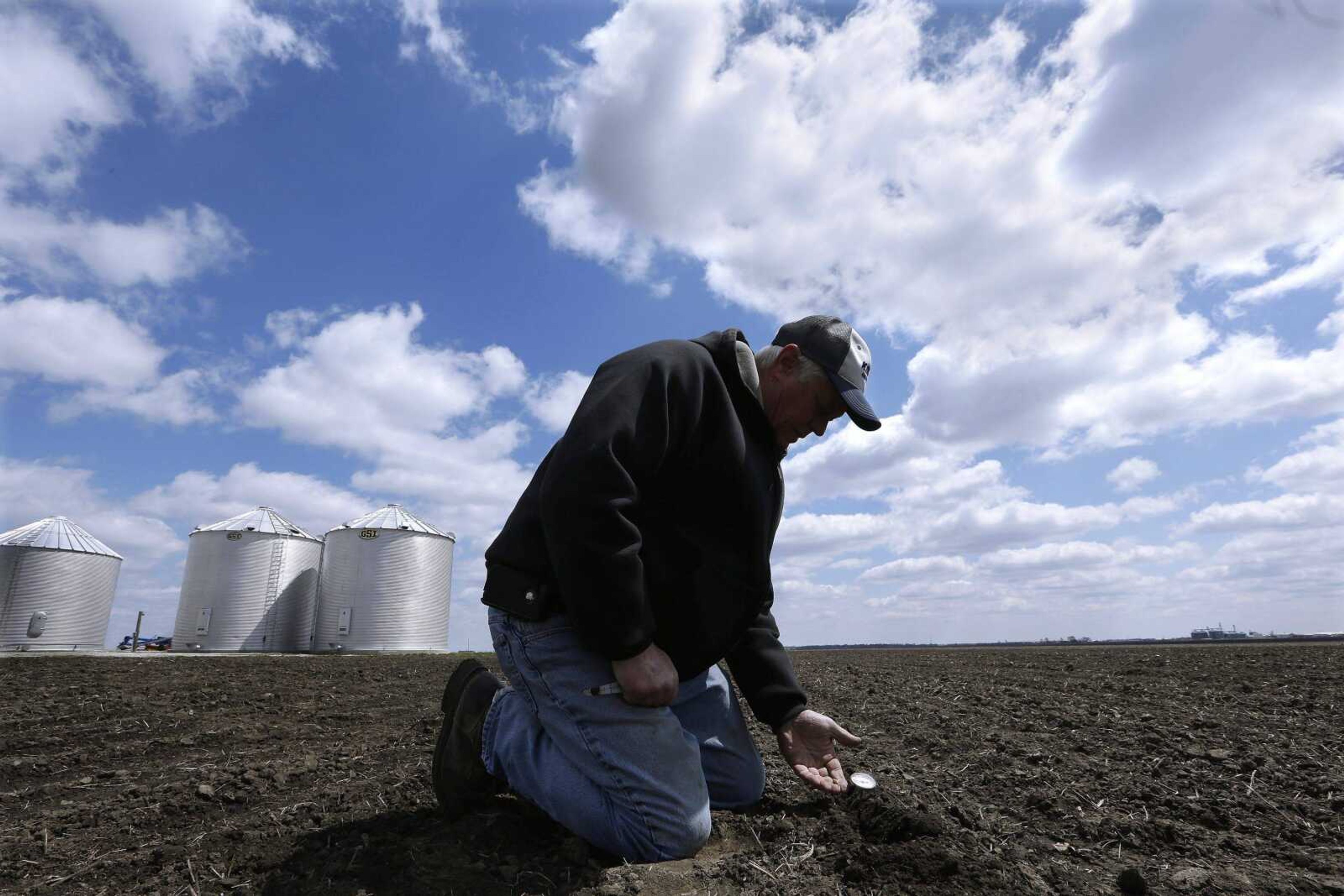 Central Illinois corn and soybean farmer Garry Niemeyer inspects soil temperature and the sprouting of corn seeds he planted earlier as a test April 15 in Auburn, Ill. Just 6 percent of this year&#8217;s corn crop has been planted. (Seth Perlman ~ Associated Press)