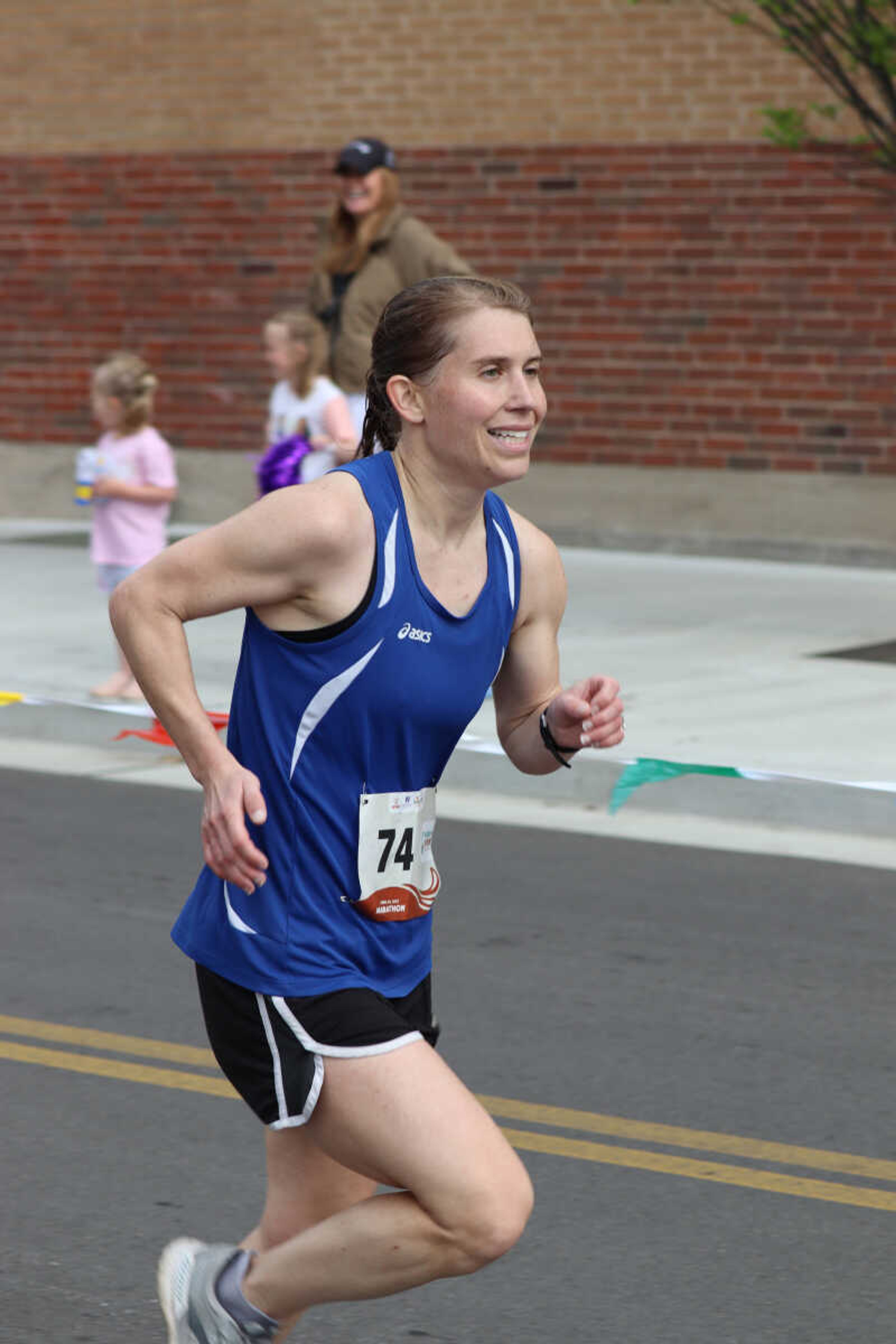 Marathon runner Kellie Shimer  smiles while making her through last stretch of the marathon.