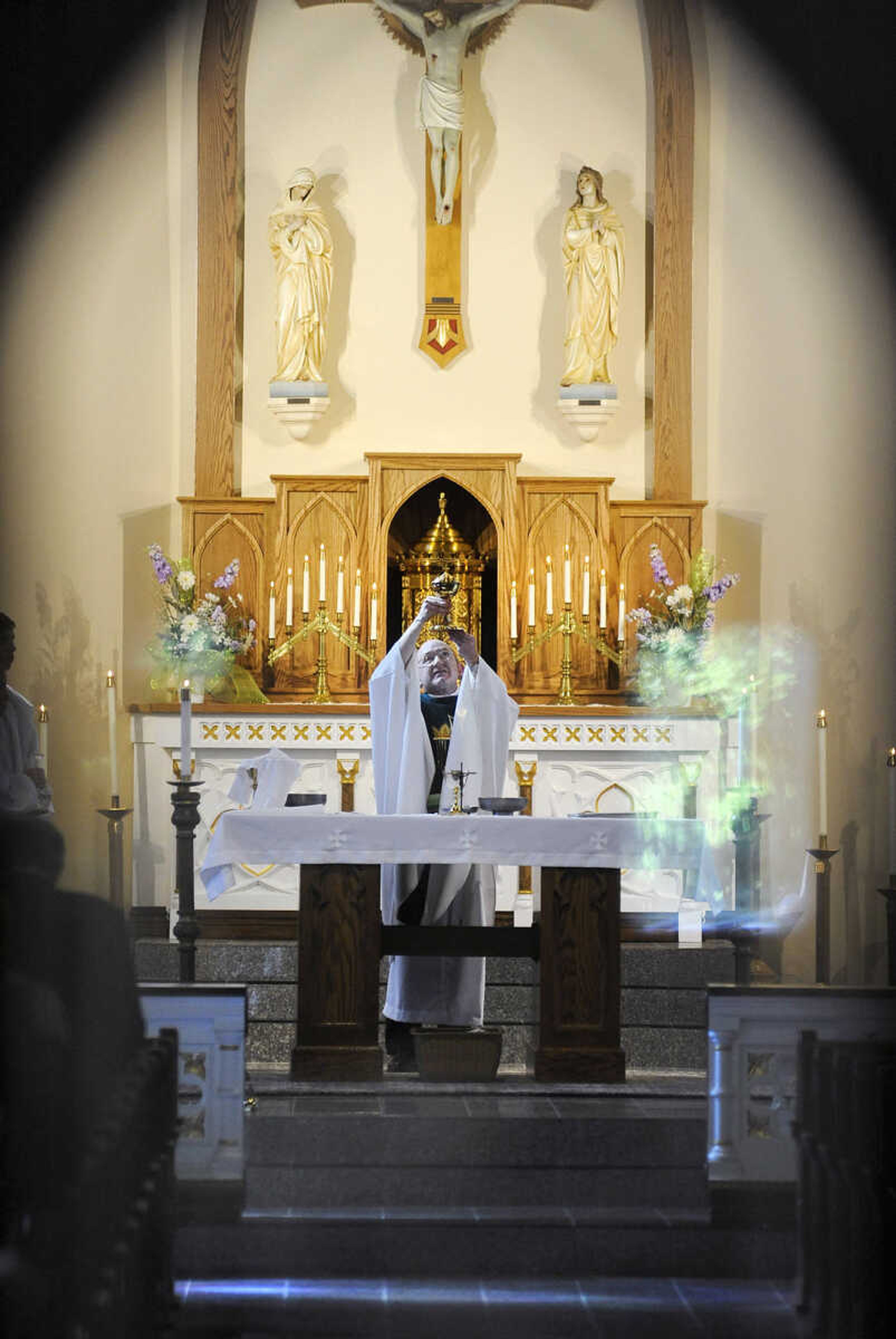 LAURA SIMON ~ lsimon@semissourian.com

The Rev. David Coon raises the chalice after communion during the first parish mass in the newly remodeled St. John's Catholic Church in Leopold, Missouri on Sunday, May 29, 2016.