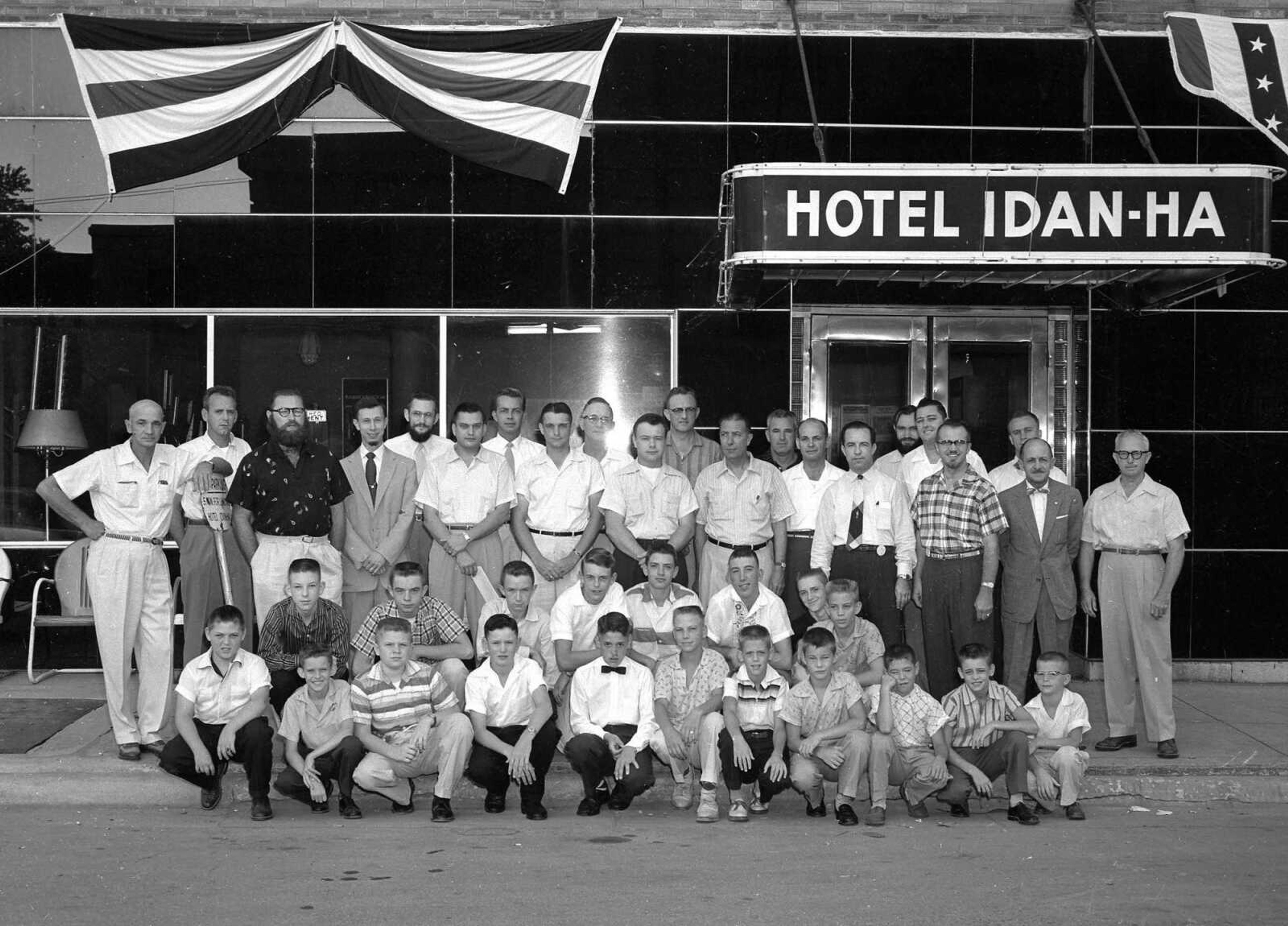 Aug. 17, 1956 Southeast Missourian.
These are youngsters who received courtesy awards for their performance during the recent Little League and Babe Ruth baseball seasons and members of the Breakfast Optimist Club who presented the awards at a meeting Monday. They are, from left to right, front row: John Yuracko, Jerry Jenkins, Charles Vandivort, Charles Reed, Floyd King, Terry Heuer, Jerry Suedekum, Bob Dacus, Richard Ikerman, Jack Smith and Ray Schnurbusch. Second row: Keith Lane, Dennis Herrmann, Gary Stevens, Jack Hawk, David Gaither, Bob Hoffer, Tom Froemsdorf and Rob McBride. Back row, standing, members of the Optimist Breakfast Club: Hugh May, Thomas Cooper, Clifford Hitt, J.J. Russell, Hugo Lang, William Winkler, Jack Kinnnaw, James Reinagel, James F. Miller, Dr. Jo Robert Cochran, Paul Lasater, John Montgomery, Al Hoskin, Dean Butler, Jon Roberts, Robert Cook, Travis Moore, Rolland Schlieve, Dr. Charles P. McGinty, Edgar Bock and T.C. Hill. (G.D. Fronabarger/Southeast Missourian archive)
[Cape Girardeau was celebrating its sesquicentennial at this time. Just six of the 21 men have some sort of facial hair.]