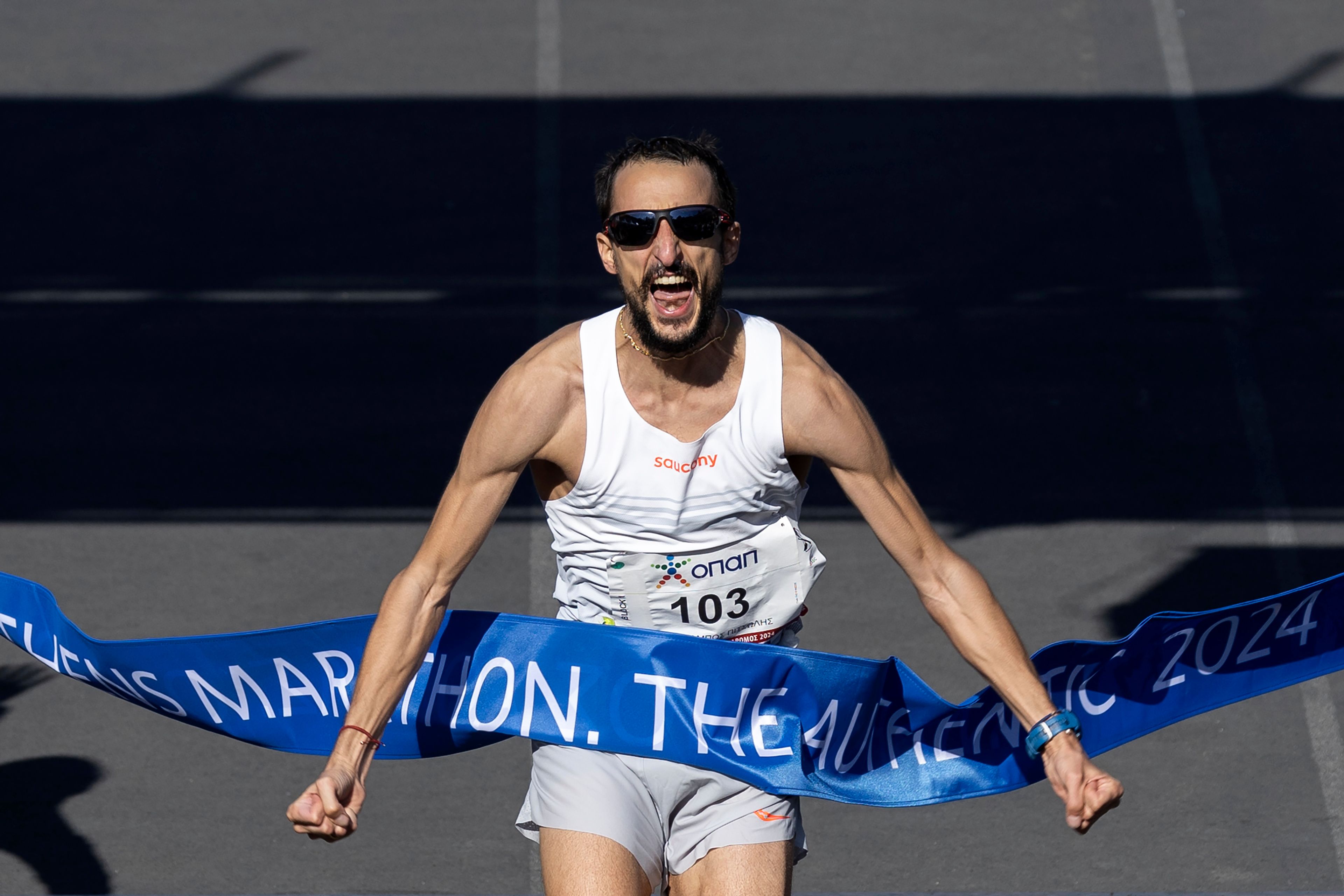 Charalampos Pitsolis of Greece crosses the finish line to win the 41st Athens Marathon, in Athens, Greece, Sunday, Nov. 10, 2024. (AP Photo/Yorgos Karahalis)