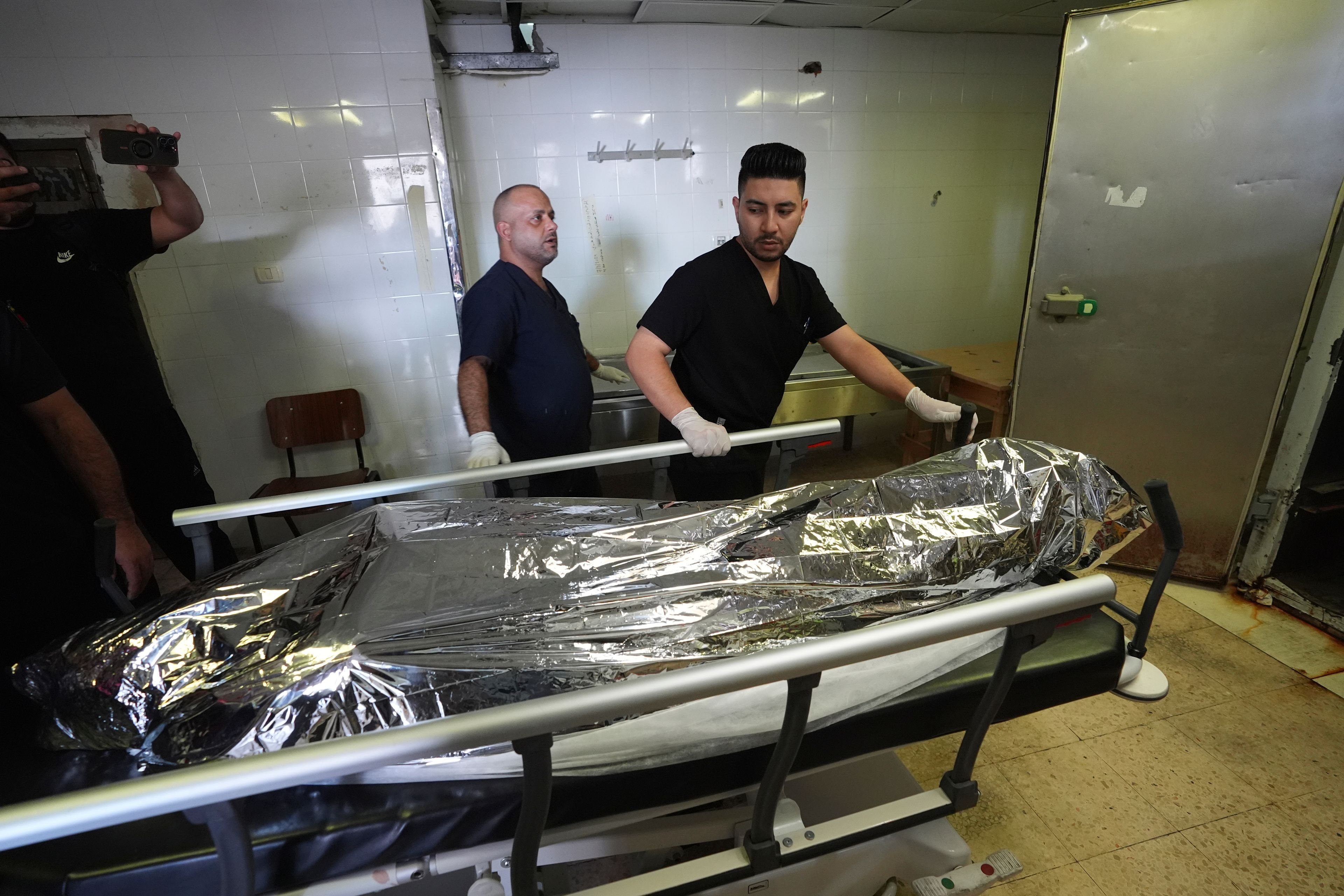 Palestinian paramedics move the body of Aysenur Ezgi Eygi, 26, who was fatally shot by Israeli soldiers while participating in an anti-settlement protest in the West Bank, at the morgue of the Rafedia hospital, in the West Bank city of Nablus Friday, Sept. 6, 2024. (AP Photo)