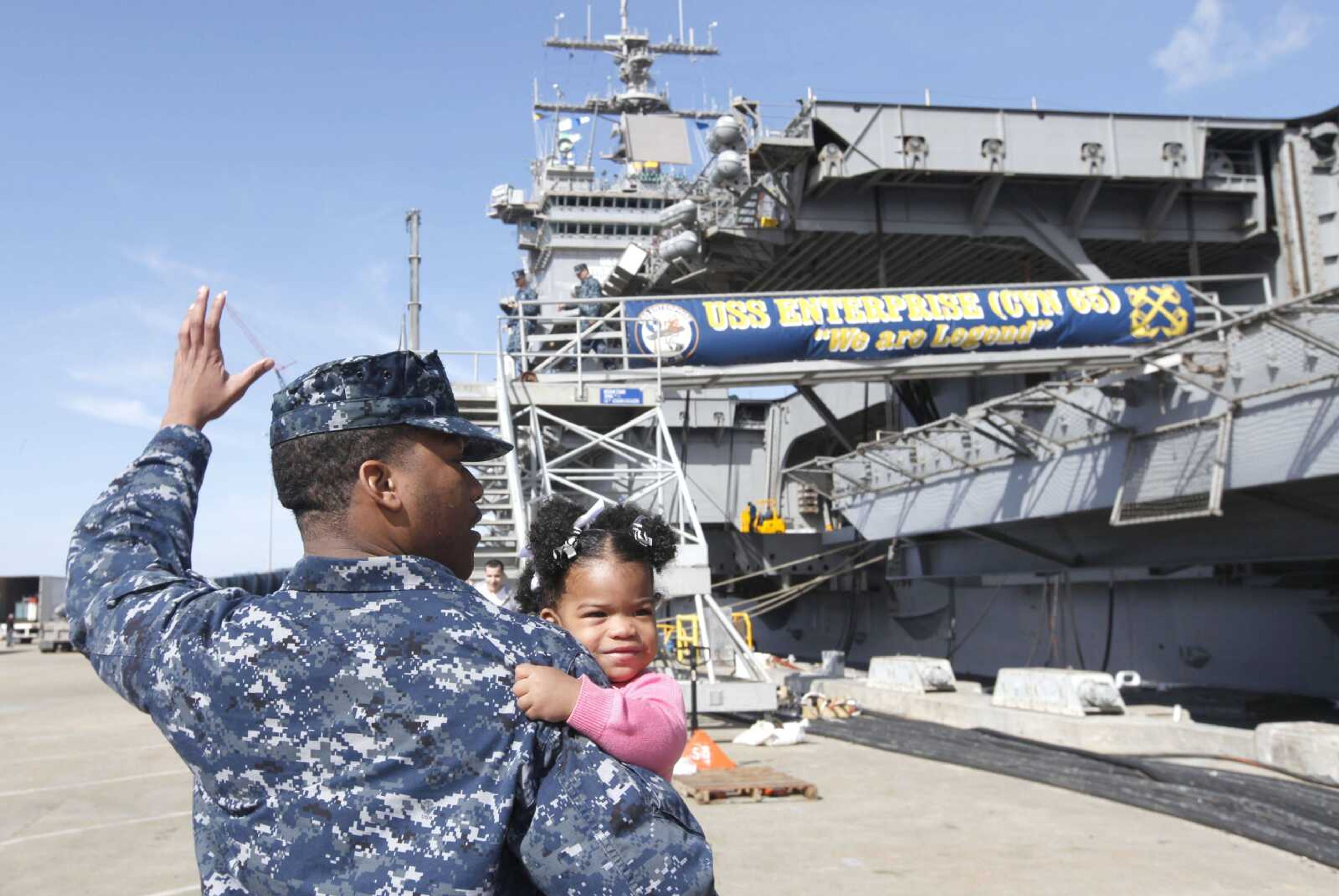 Petty Officer 3rd Class Michael Joseph, carries his daughter Maleah, 1, to his re-enlistment ceremony Thursday aboard the nuclear powered aircraft carrier USS Enterprise at the Norfolk Naval Station in Norfolk, Va. The ship begins its final deployment today. (Steve Helber ~ Associated Press)