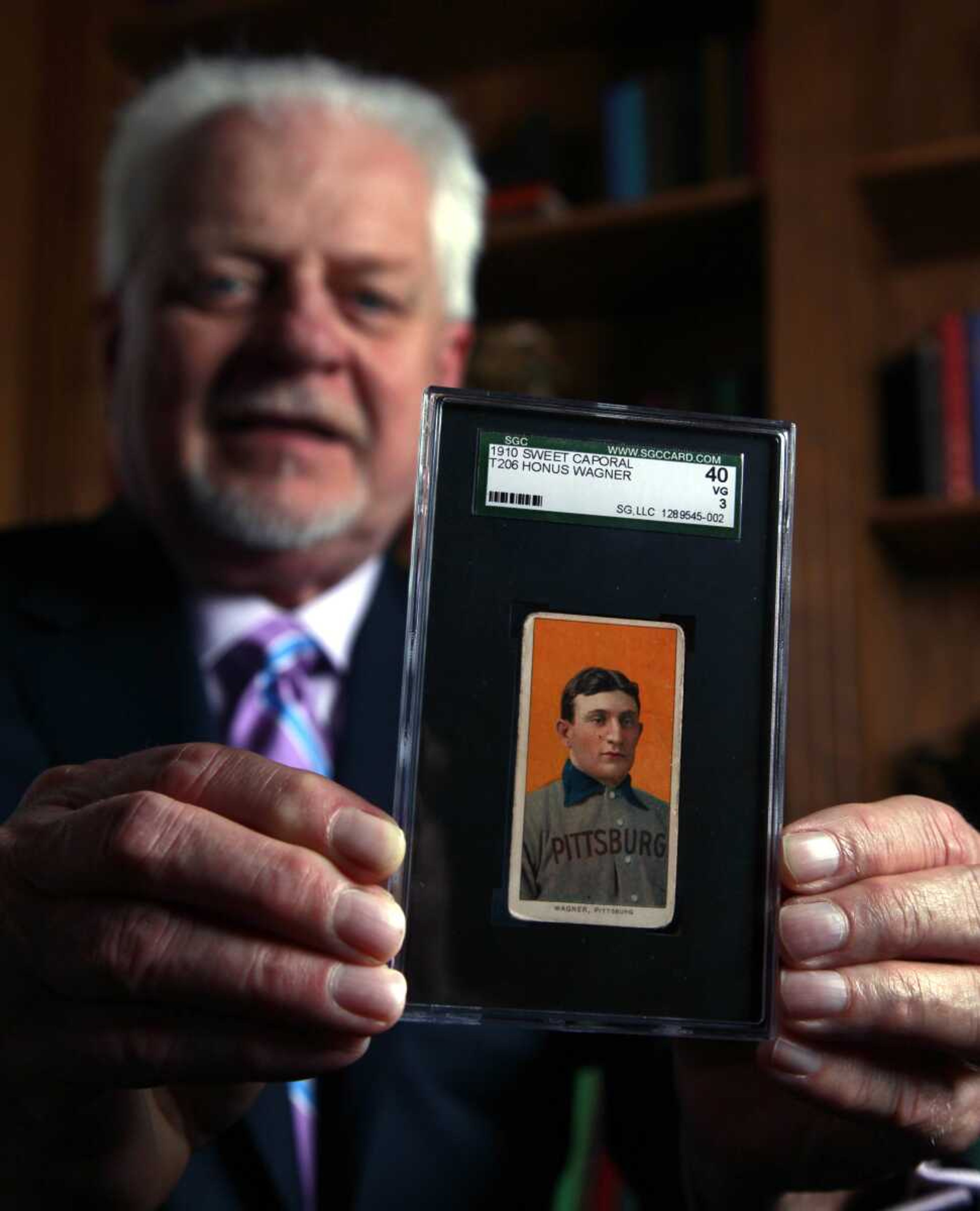 Bill Goodwin held a 1909 Honus Wagner baseball card Monday in Sunset Hills, Mo. Goodwin will facilitate an online auction starting today for the card, one of the most sought-after sports collectibles in the world, and expects it to fetch at least $1 million and perhaps as much as $1.5 million. (AP Photo/Jeff Roberson)