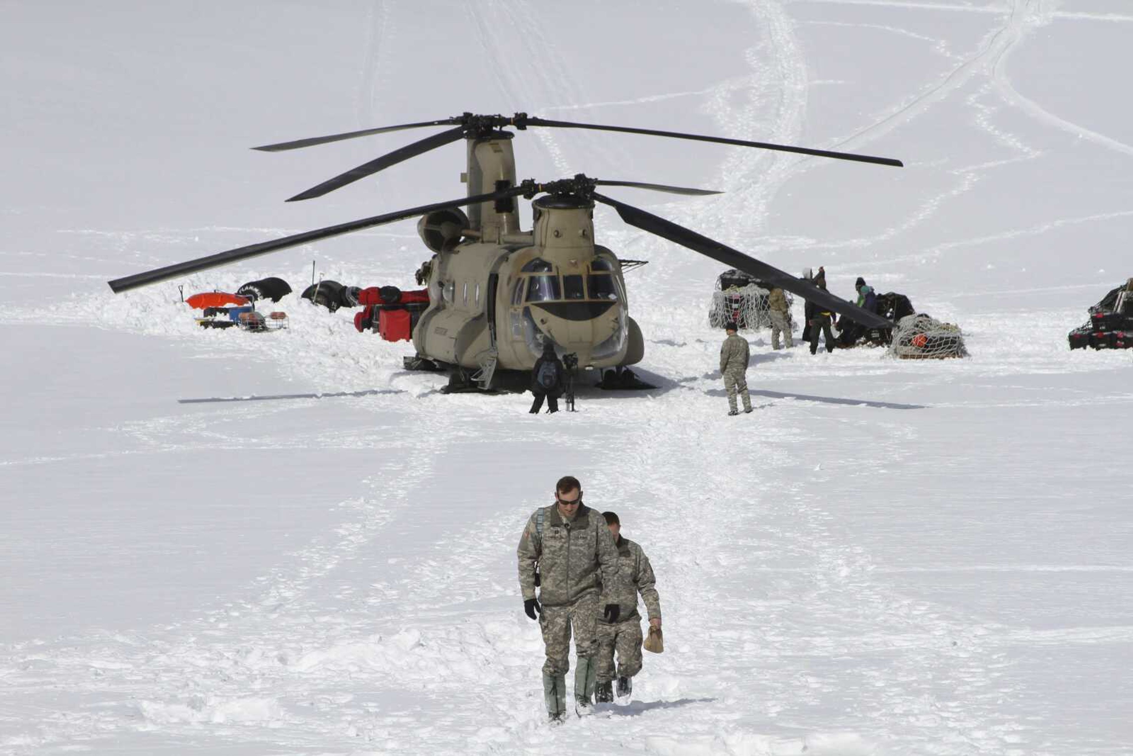 Capt. Corey Wheeler, front, commander of B Company, 1st Battalion, 52nd Aviation Regiment at Fort Wainwright, Alaska, walks away from a Chinook helicopter that landed on the glacier April 24, 2016, near Denali, on the Kahiltna Glacier in Alaska. The U.S. Army helped set up base camp on North America's tallest mountain.