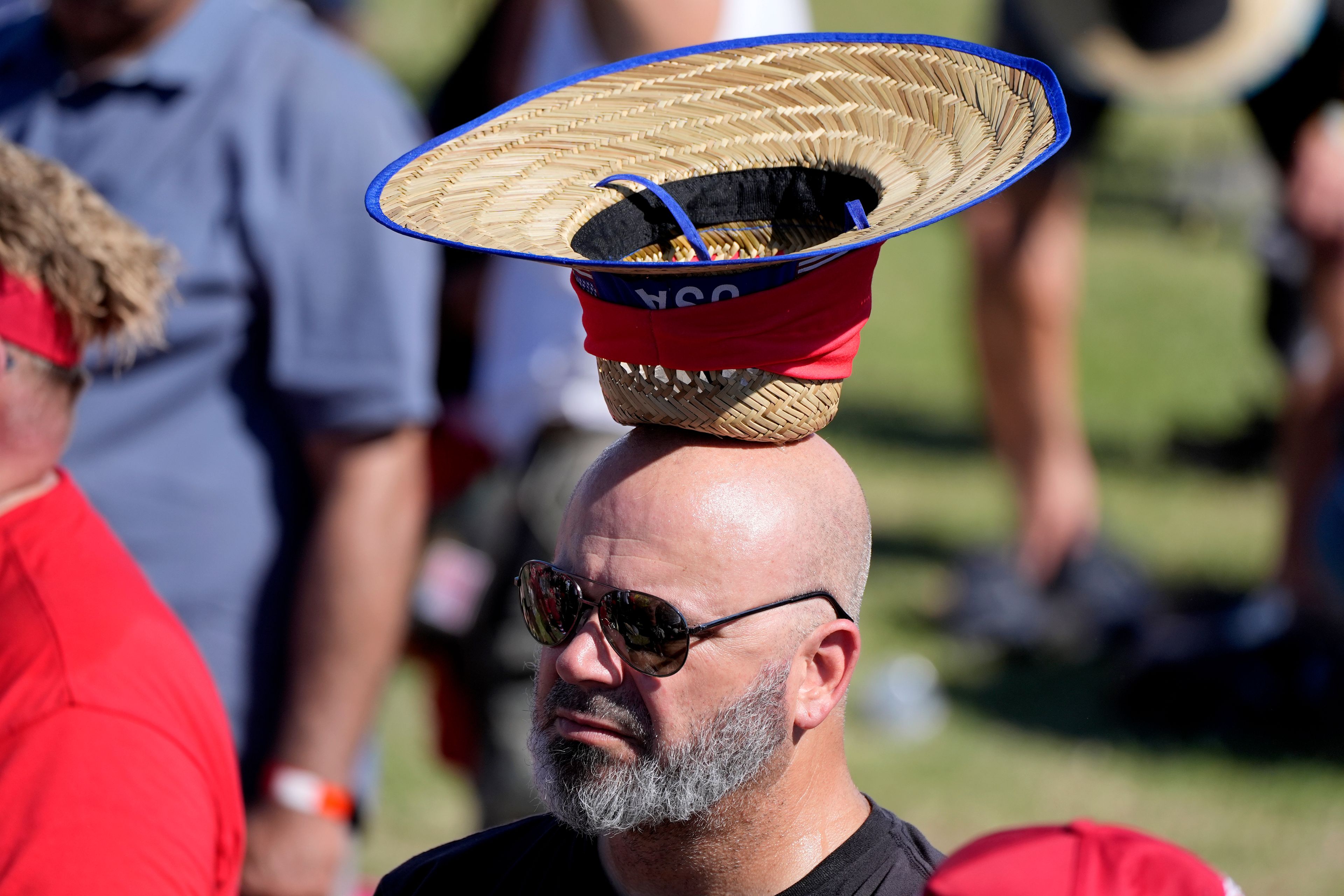 An attendee, with ice in his hat to cool off, attends a campaign rally for Republican presidential nominee former President Donald Trump at the Calhoun Ranch, Saturday, Oct. 12, 2024, in Coachella, Calif. (AP Photo/Alex Brandon)