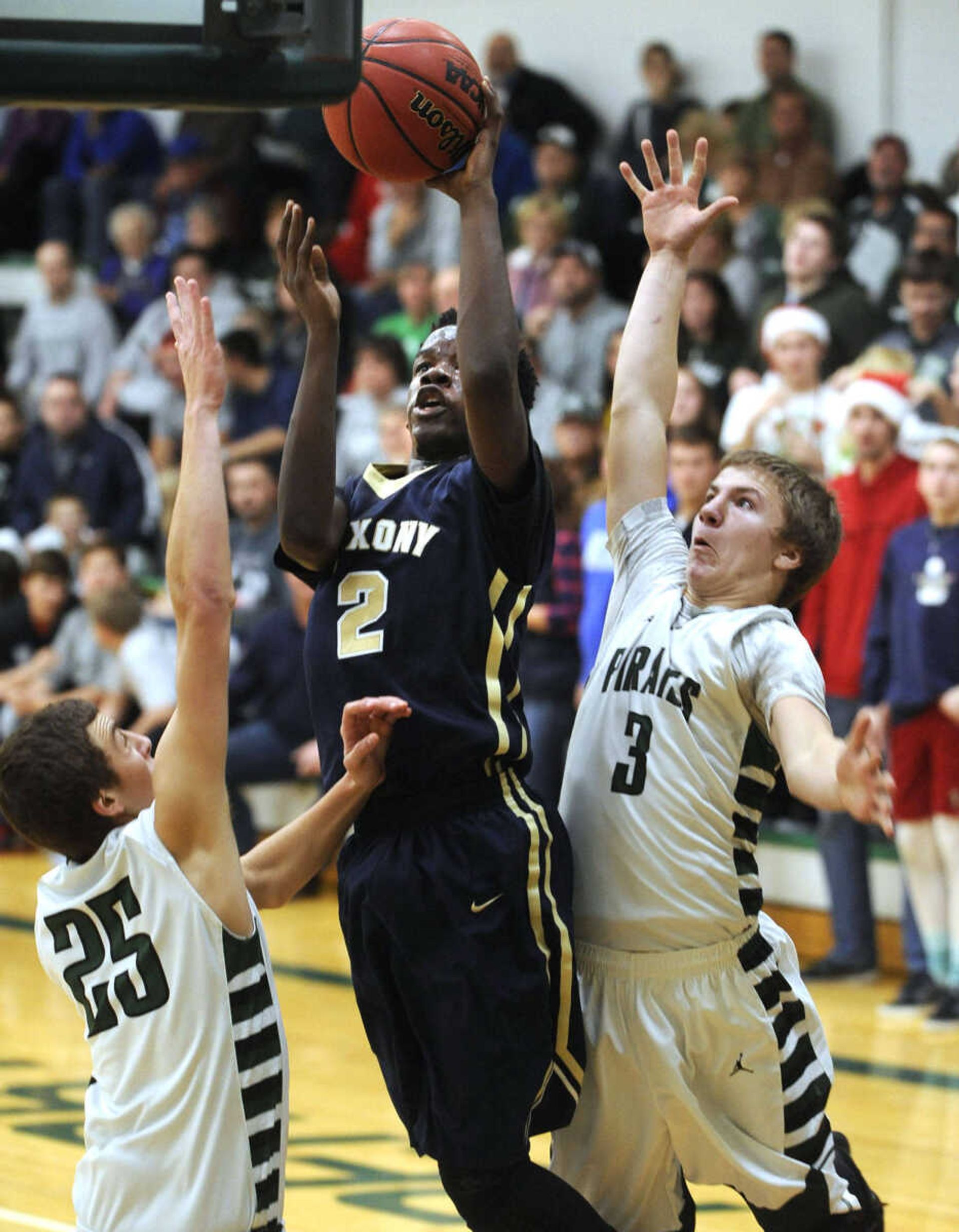 Saxony Lutheran's William Rogers shoots between Perryville's Ryan Noland, left, and Aaron Mueller during the second quarter Friday, Dec. 18, 2015 in Perryville, Missouri. (Fred Lynch)