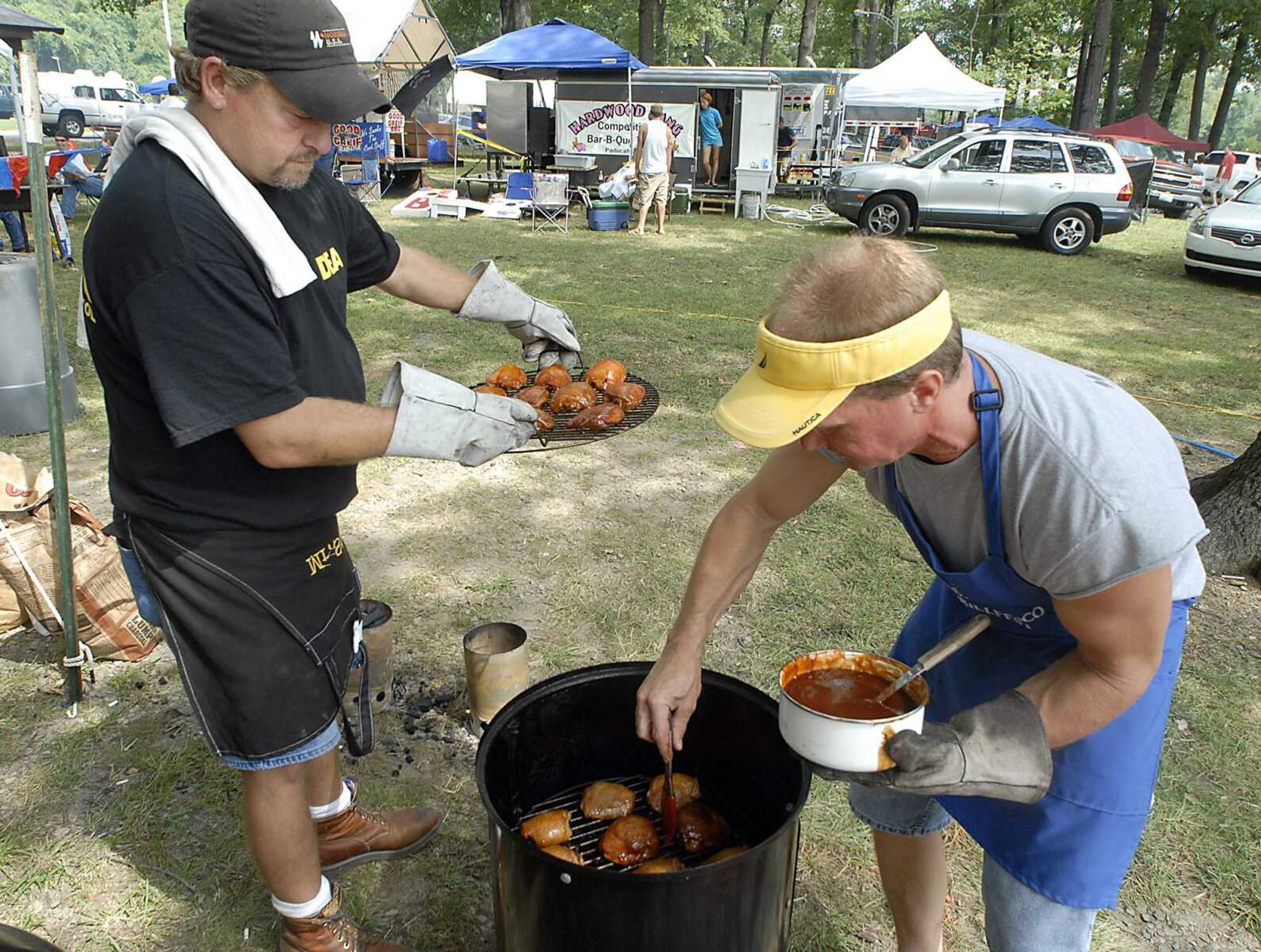 FRED LYNCH ~ flynch@semissourian.com
Tony Watson, left, and Roger Petzoldt with Nordenia - DCO Grillfest team put special sauce on their chicken at Cape BBQ Fest.