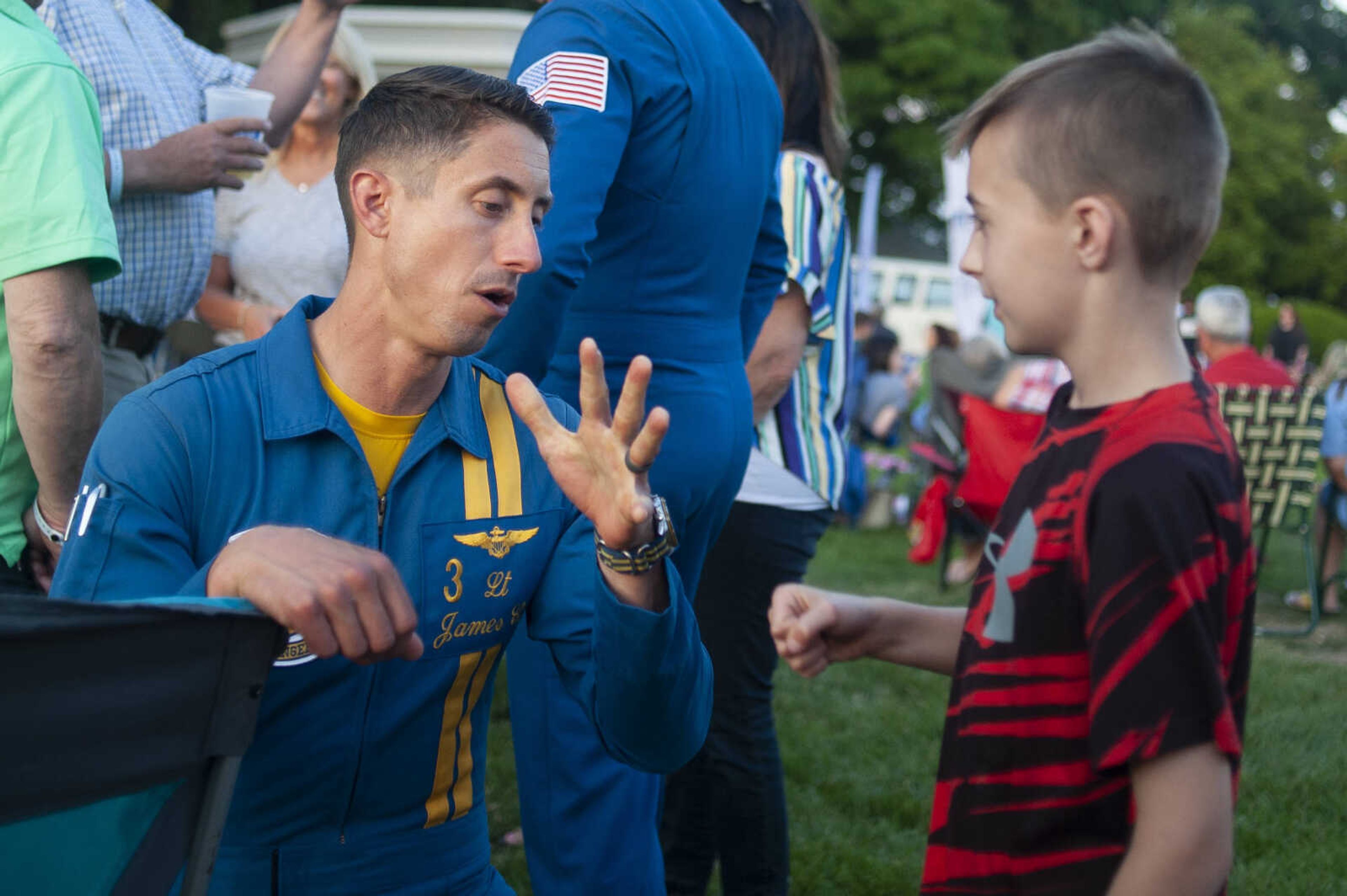 Blue Angels pilot Lt. James Cox concludes a fist bump with Keiton Miller of Jackson, 12, during the season's first Tunes at Twilight on Friday, May 17, 2019, at Ivers Square near Common Pleas Courthouse in Cape Girardeau.