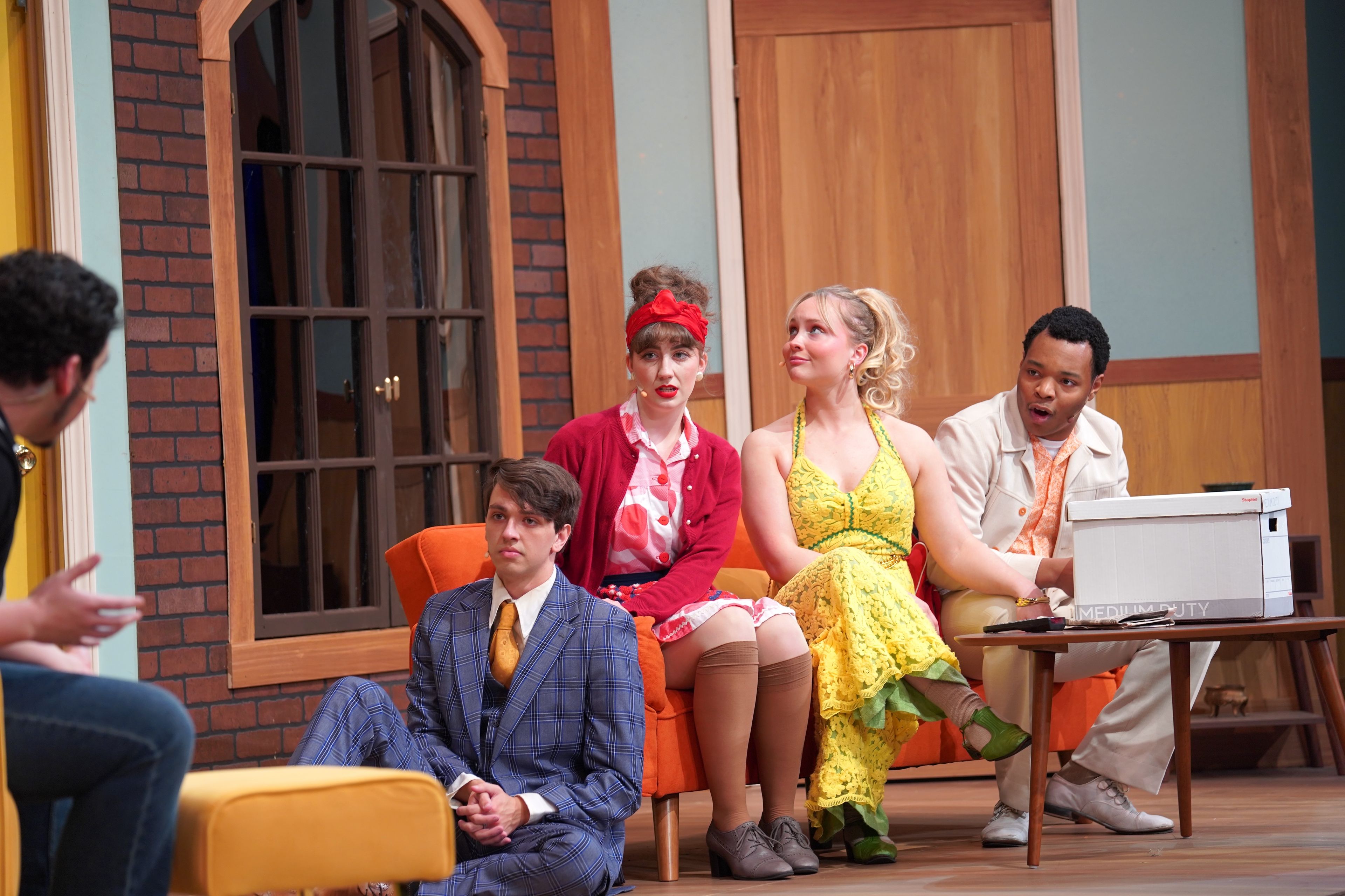 Cast members Zander Card, Joy Ross, Abbie Van Pelt and Zay Williams sit onstage while their characters are directed by Lloyd Dallas played by Miko Hare in the play 'Noises Off' on Thursday, Sept. 26  in the Bedell Performance Hall.