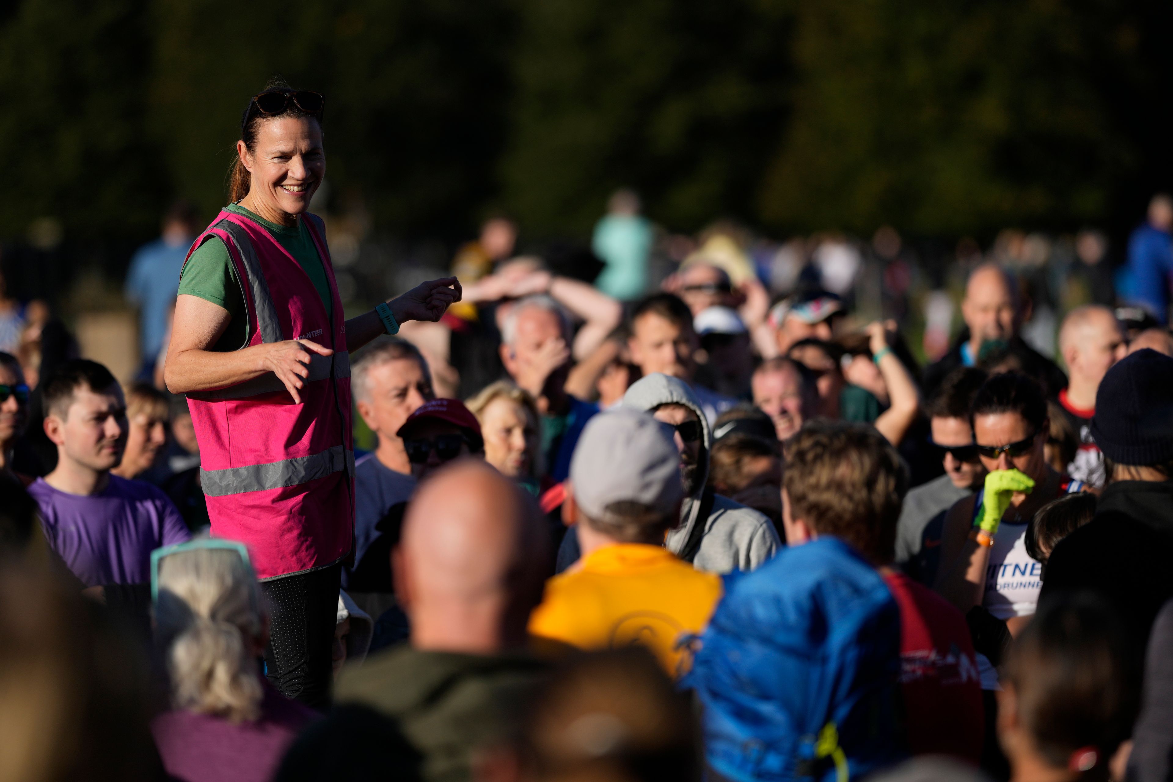 Wendy Stokes, one of the core organisers of the Bushy Park parkrun, gives her briefing before the start of the parkrun event in Bushy Park, southwest London, Saturday, Sept. 28, 2024. (AP Photo/Alastair Grant)