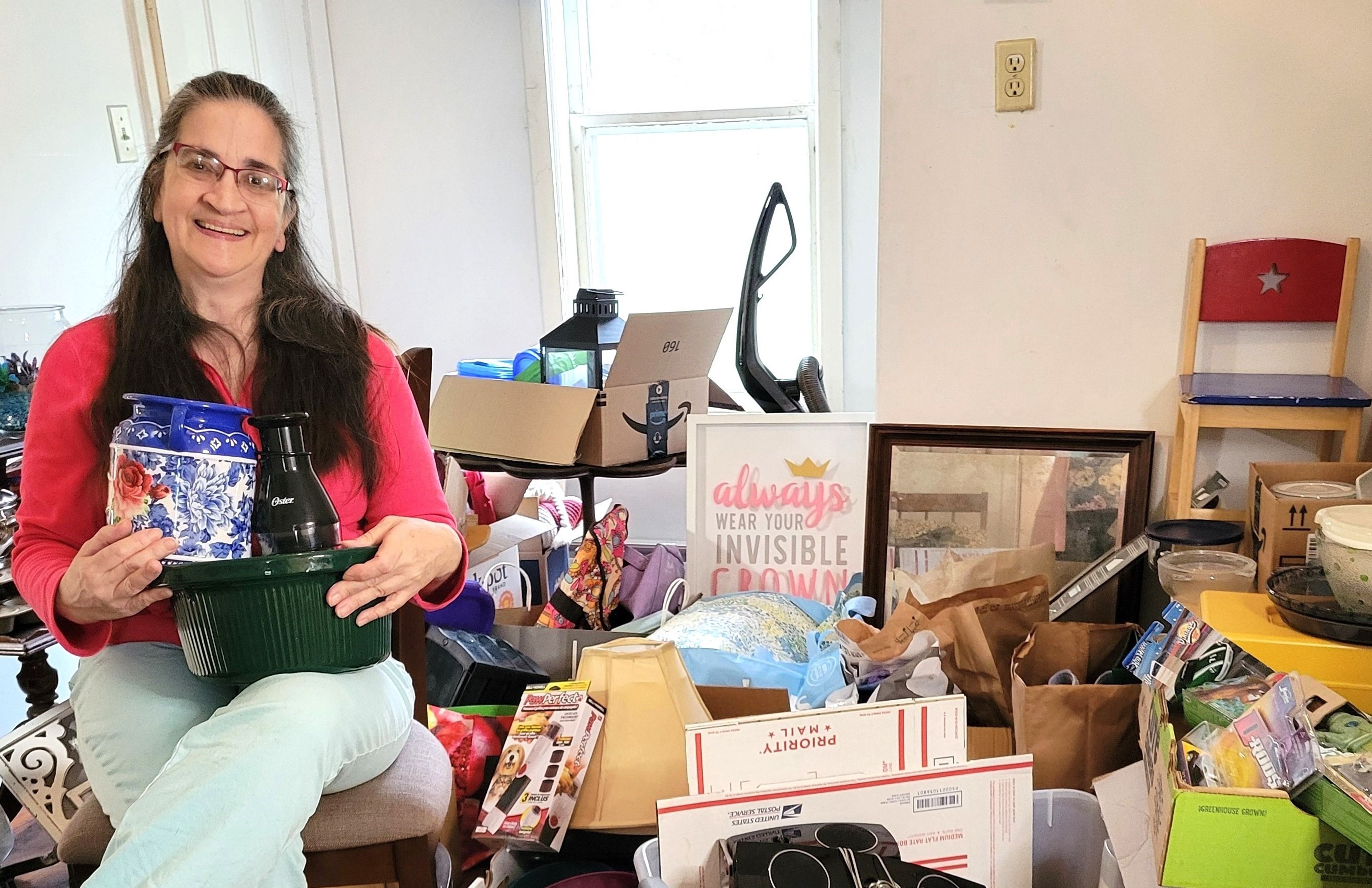Molly Copeland is seated amidst some of the many donations that have been coming in for the yard sale she is holding May 2 and 3 to benefit “Molly’s House” - a sanctuary for veterinary mental health which Molly oversees in her home on Spring Street in Groton.