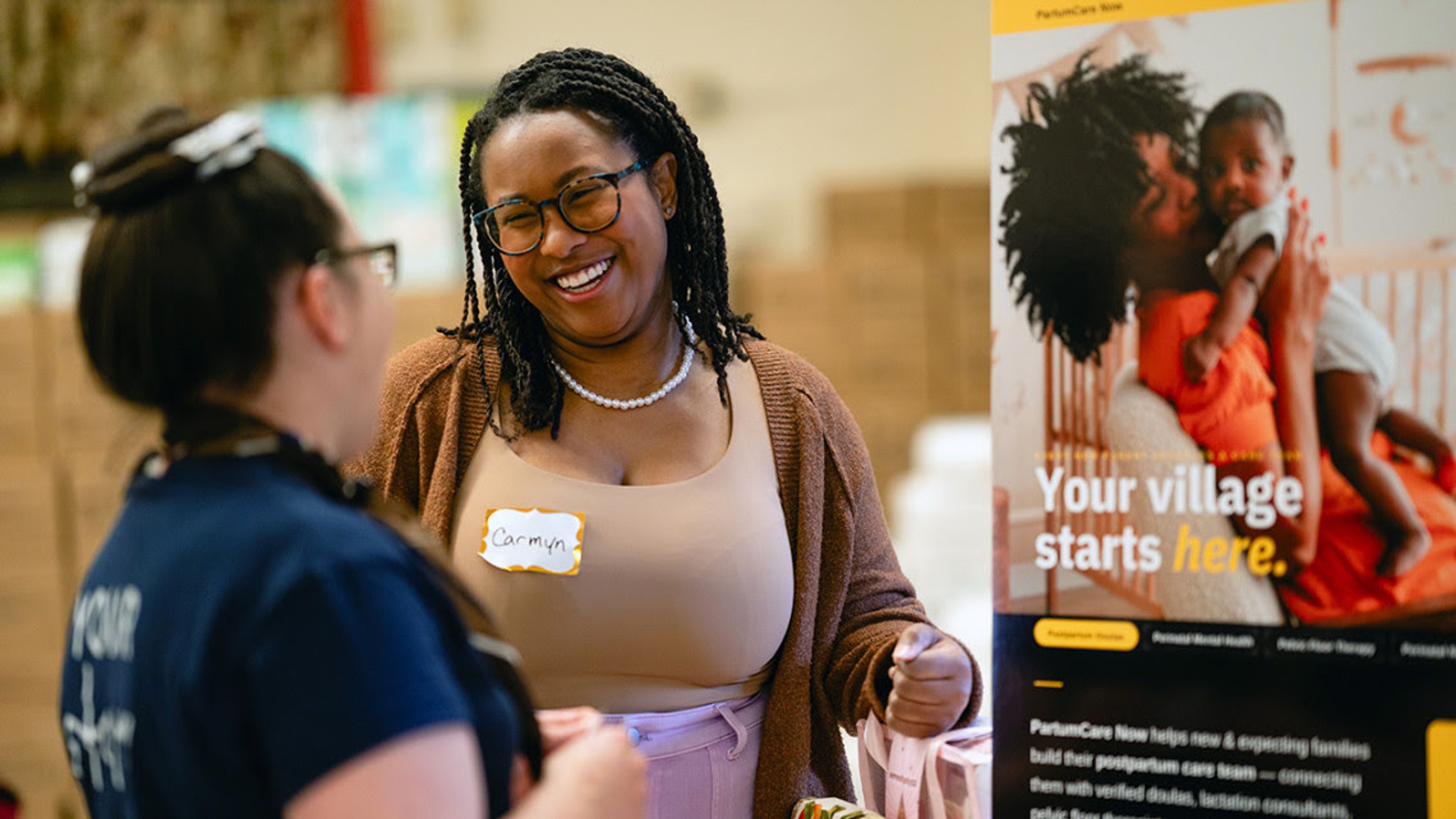 Carmyn Polk, MBA ’26, presents PartumCare Now to an attendee of the family resources fair.