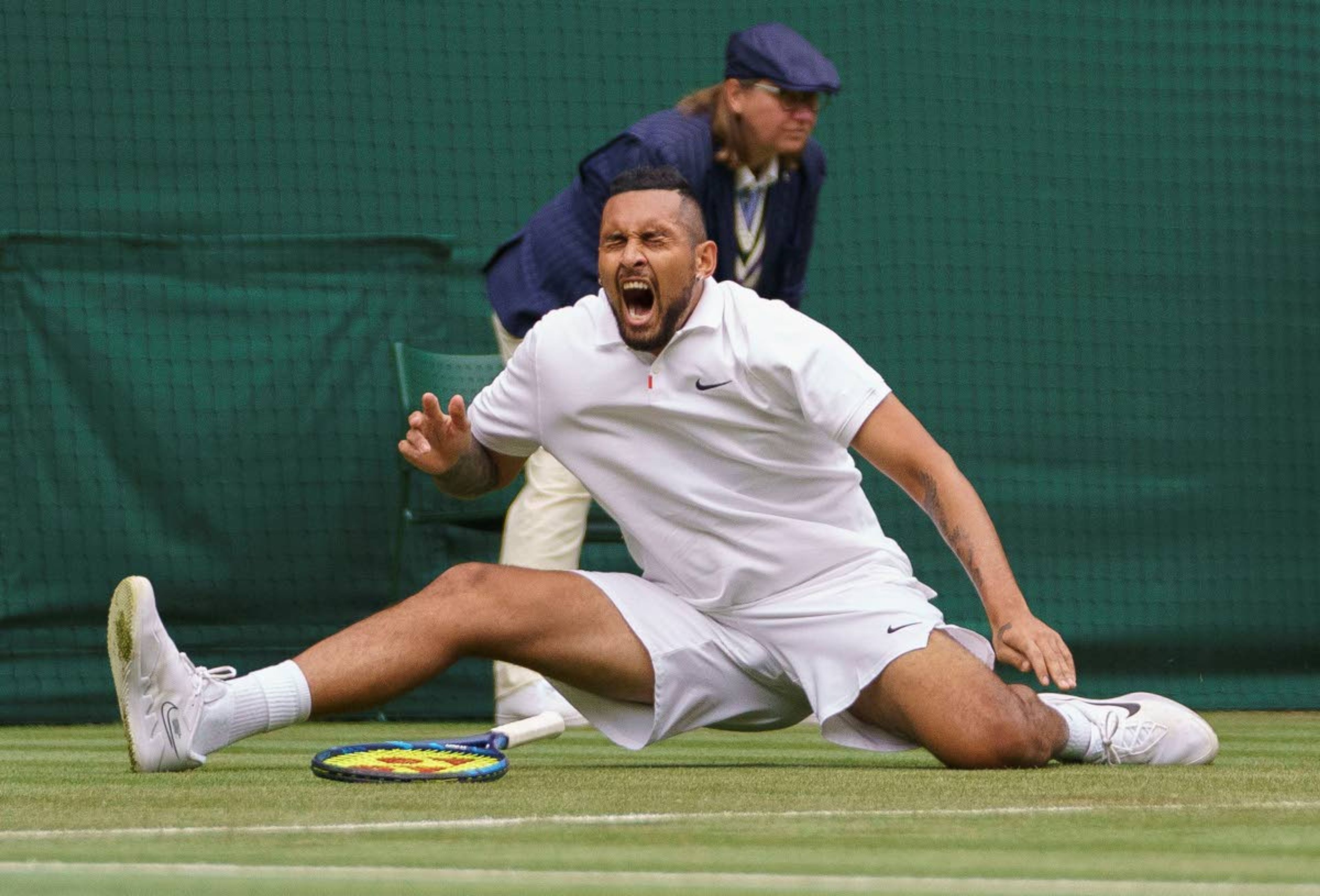 Australia's Nick Kyrgios slips after playing a return to Ugo Humbert of France during the men's singles first round match on day three of the Wimbledon Tennis Championships in London, Wednesday June 30, 2021. (Jon Super/Pool via AP)