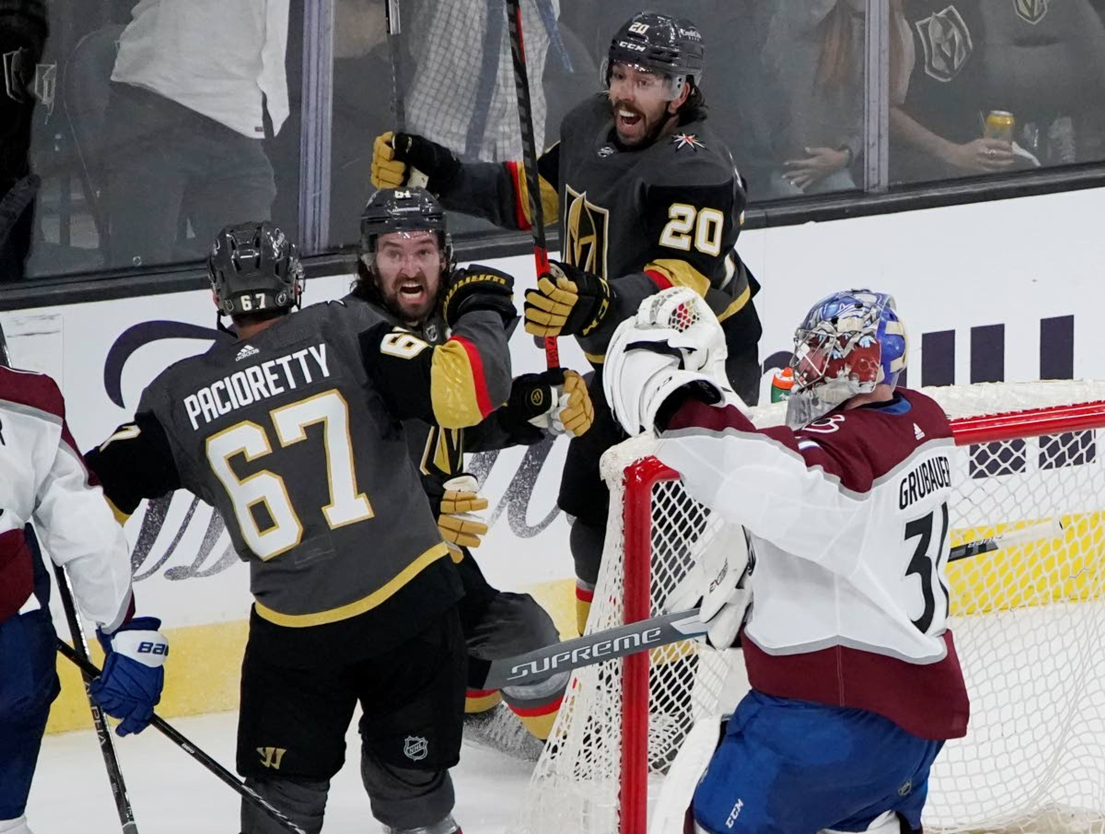 Vegas Golden Knights center Chandler Stephenson (20) and Vegas Golden Knights right wing Mark Stone (61) celebrate after Vegas Golden Knights left wing Max Pacioretty (67) scores a goal against Colorado Avalanche goaltender Philipp Grubauer (31) during the third period in Game 3 of an NHL hockey Stanley Cup second-round playoff series Friday, June 4, 2021, in Las Vegas. (AP Photo/John Locher)