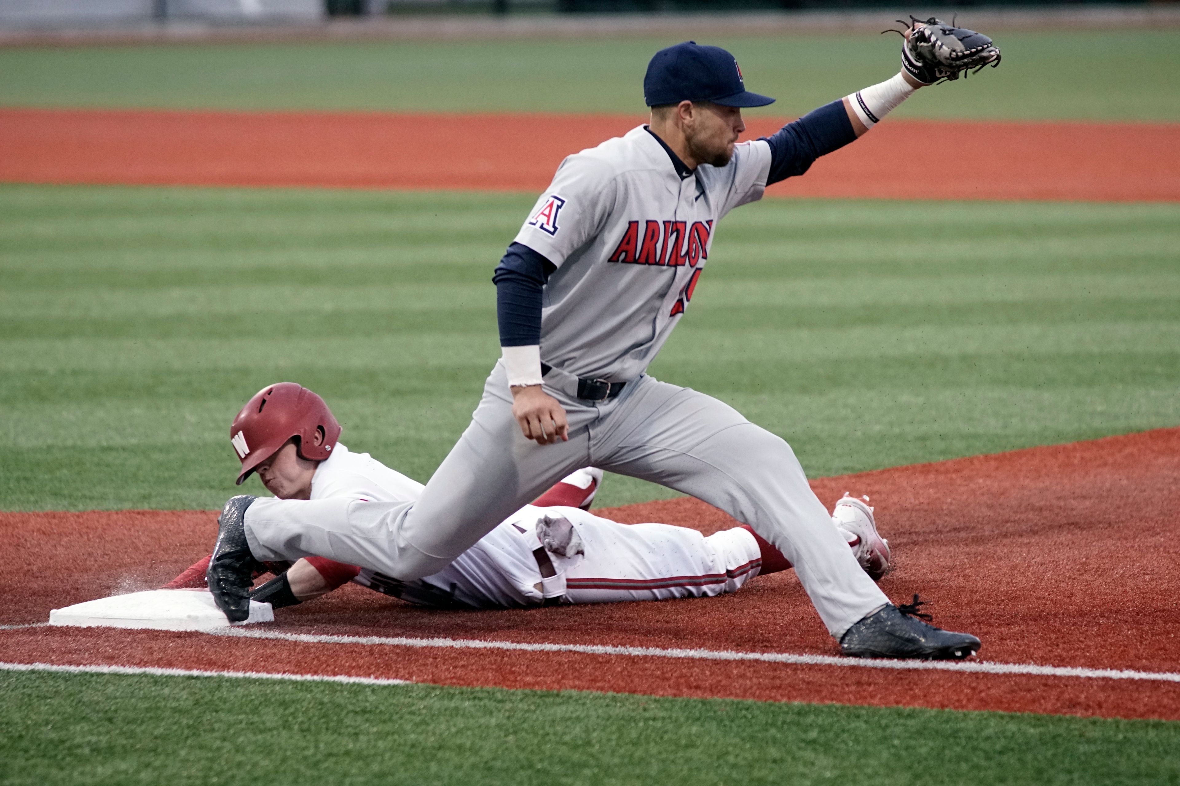 Washington State's Danny Sinatro dives safely back to first base behind Arizona's JJ Matijevic after an Arizona outfielder nabbed a fly ball and tried to pick off Sinatro during a PAC-12 game in Pullman Friday evening.