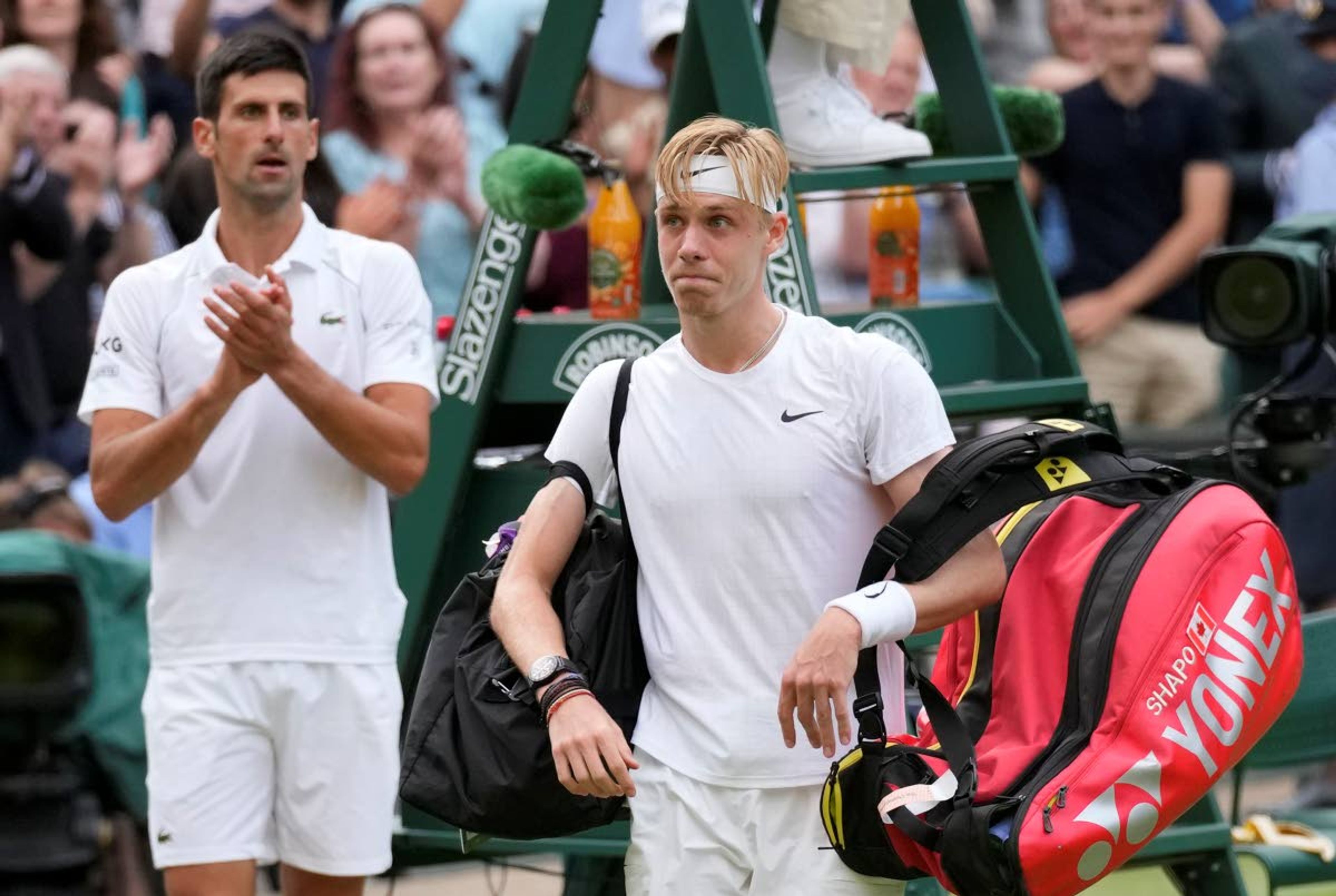 Canada's Denis Shapovalov leaves the court applauded by Serbia's Novak Djokovic at the end of the men's singles semifinals match on day eleven of the Wimbledon Tennis Championships in London, Friday, July 9, 2021. (AP Photo/Kirsty Wigglesworth)