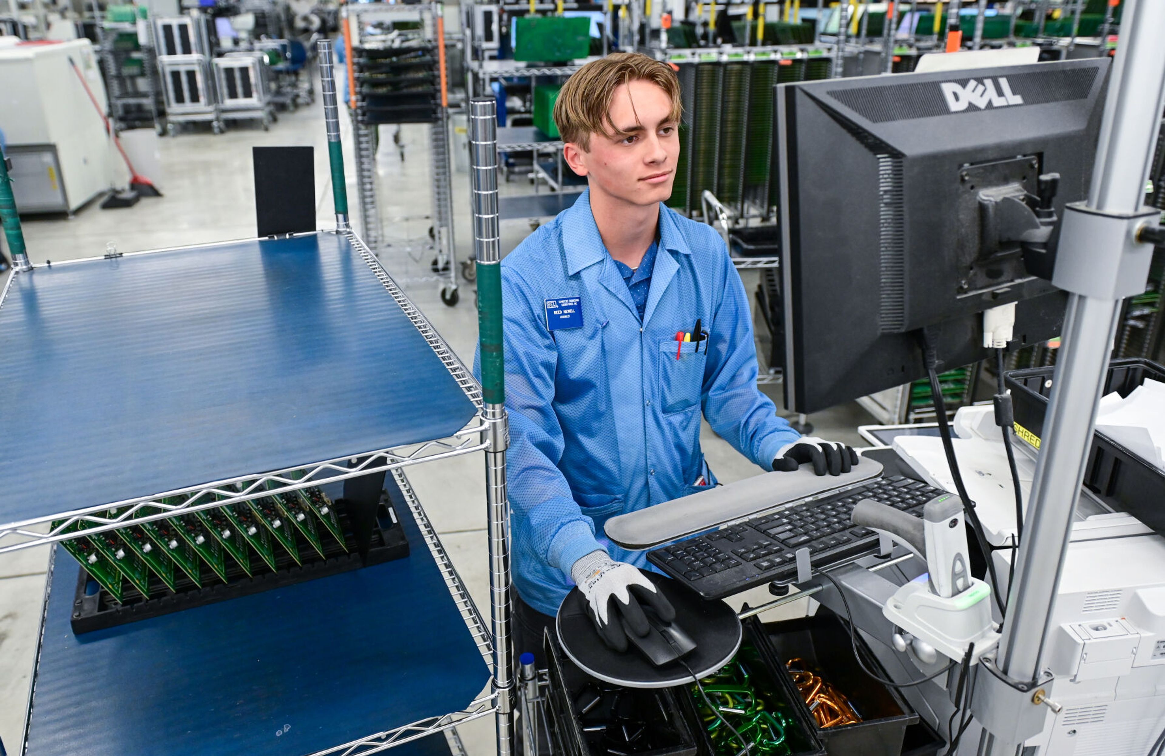 Reed Newell, a Pullman High School senior and member of the Summer Assembler Program, looks up where a batch of circuit boards need to move next for further processing at Schweitzer Engineering Laboratories on Thursday in Pullman.