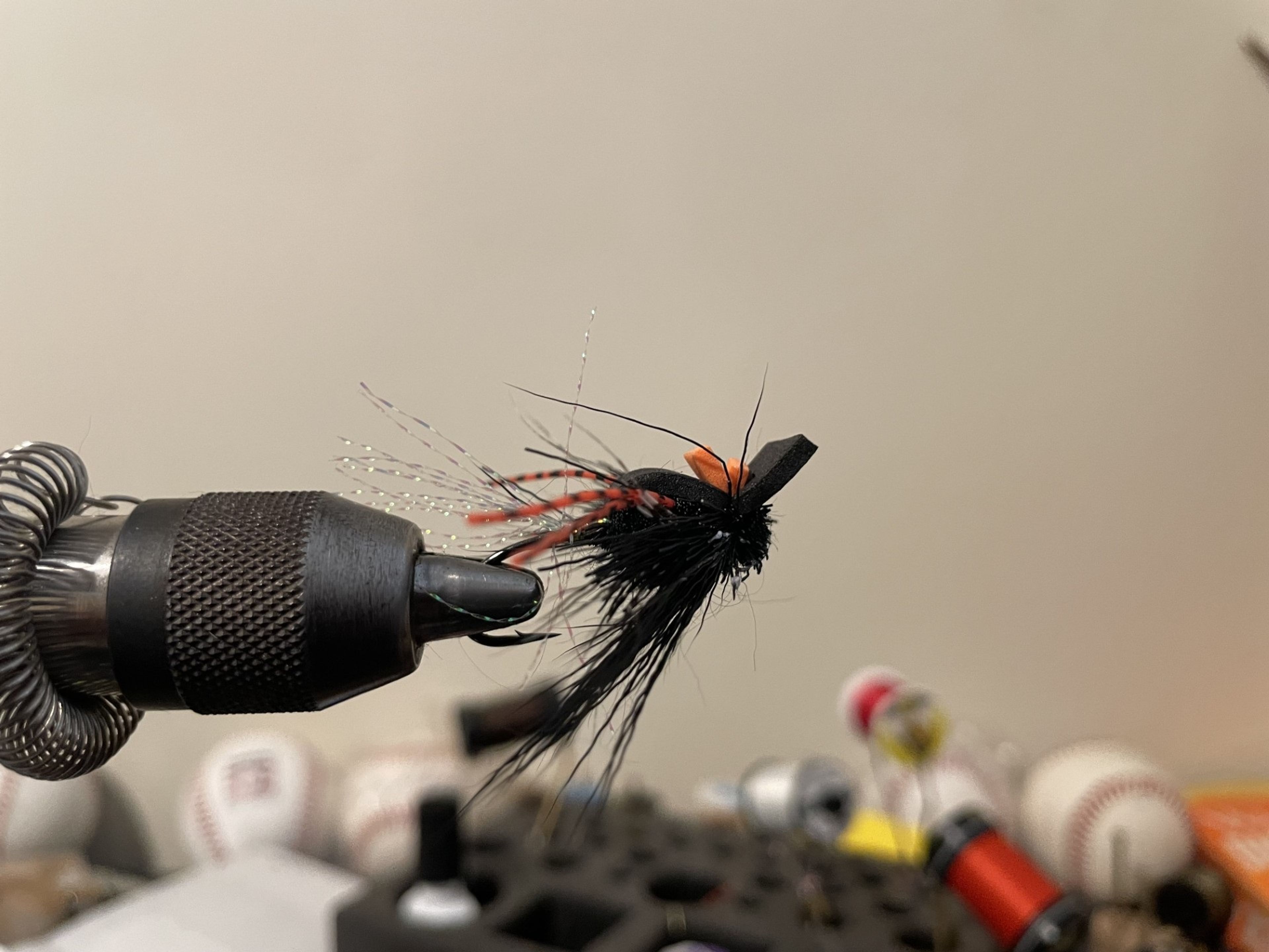 A steelhead dry fly made of black deer hair, black foam, flash and rubber legs.