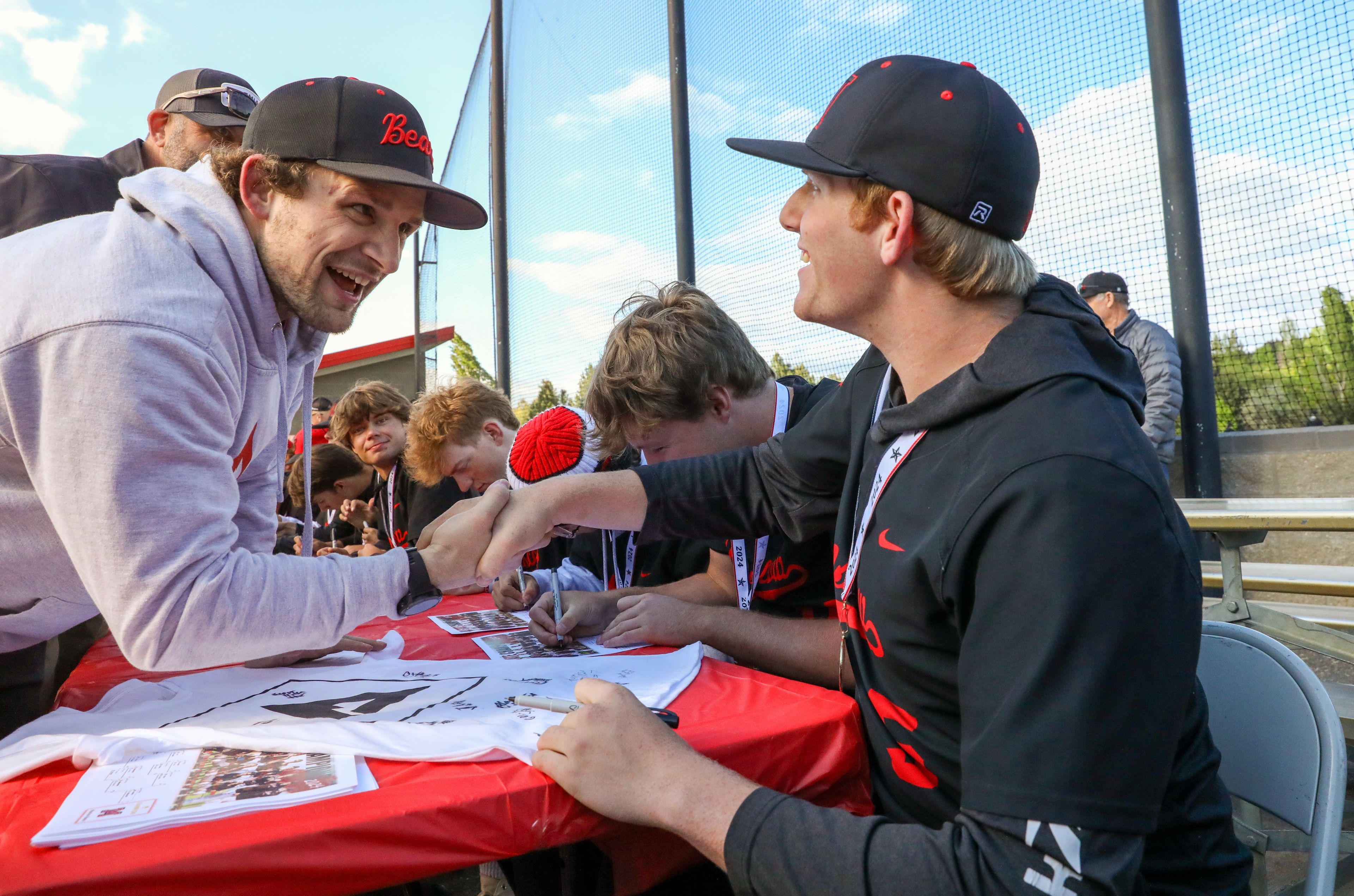 Travis Seltenreich, left, director of Reactiv Training Center where many of the Bears train, shakes hands with Moscow’s Keaton Clark at the team’s Parade of Champions celebrating their state championship win in Moscow on Thursday.