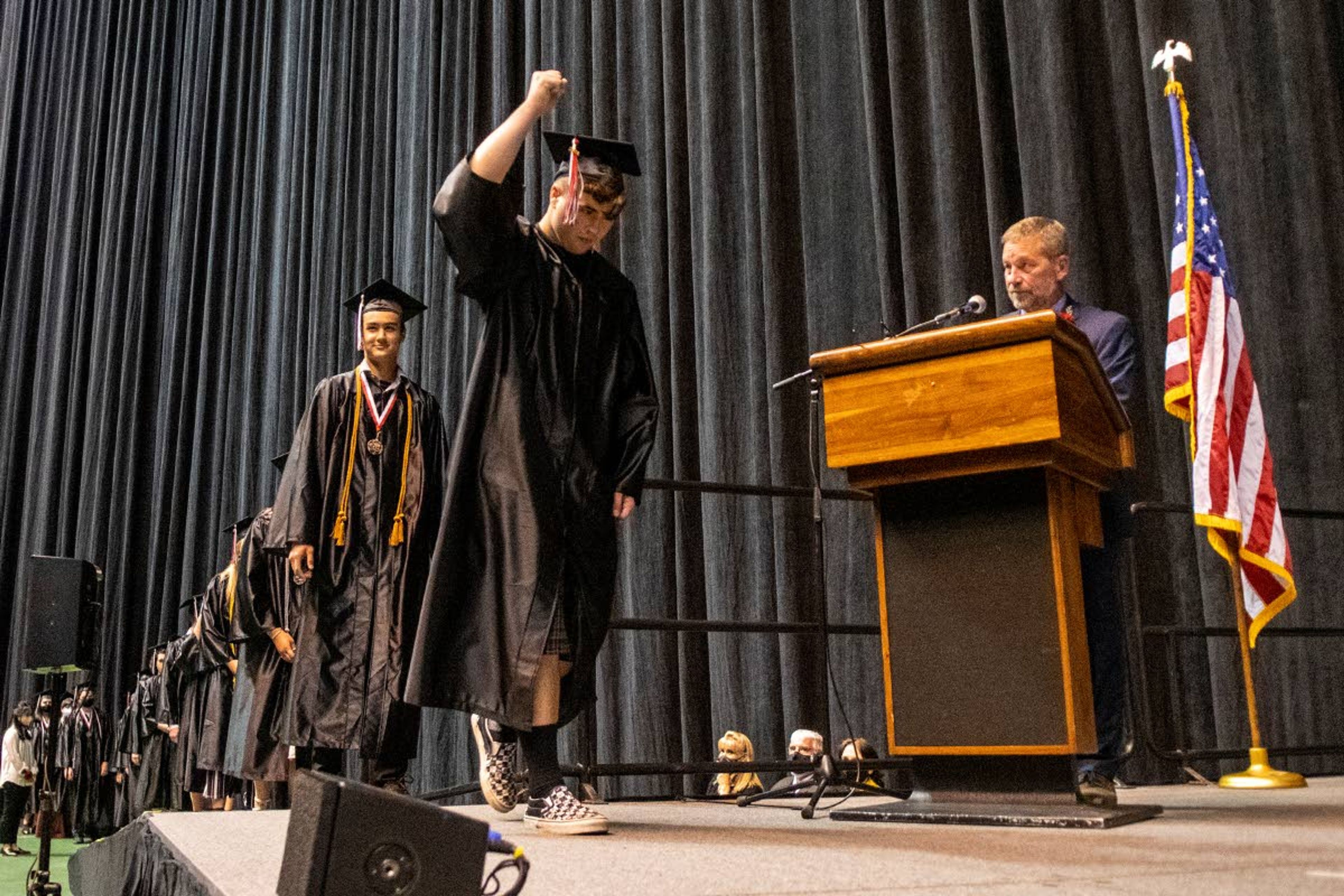 Graduate Johnathan Lake raises his fist into the air after being called across the stage to receive his diploma during the Moscow High School Class of 2021 graduation commencement at the University of Idaho’s Kibbie Dome on Friday night.