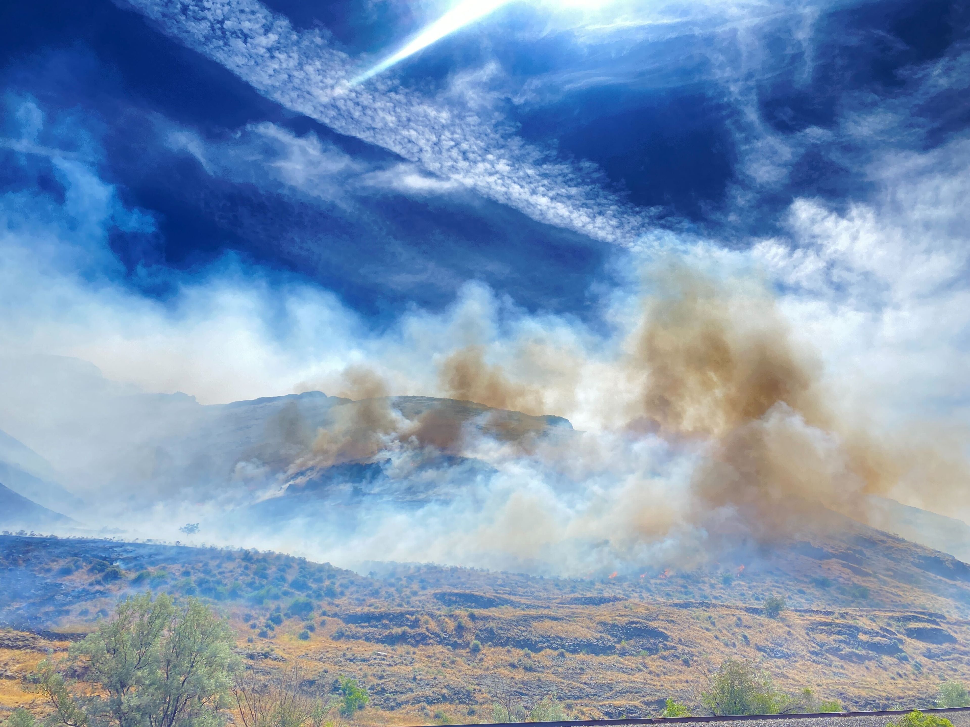 A fire burns on the hillside by Nisqually John Landing on Friday. Firefighters attack the fire with helicopter and plane drops.