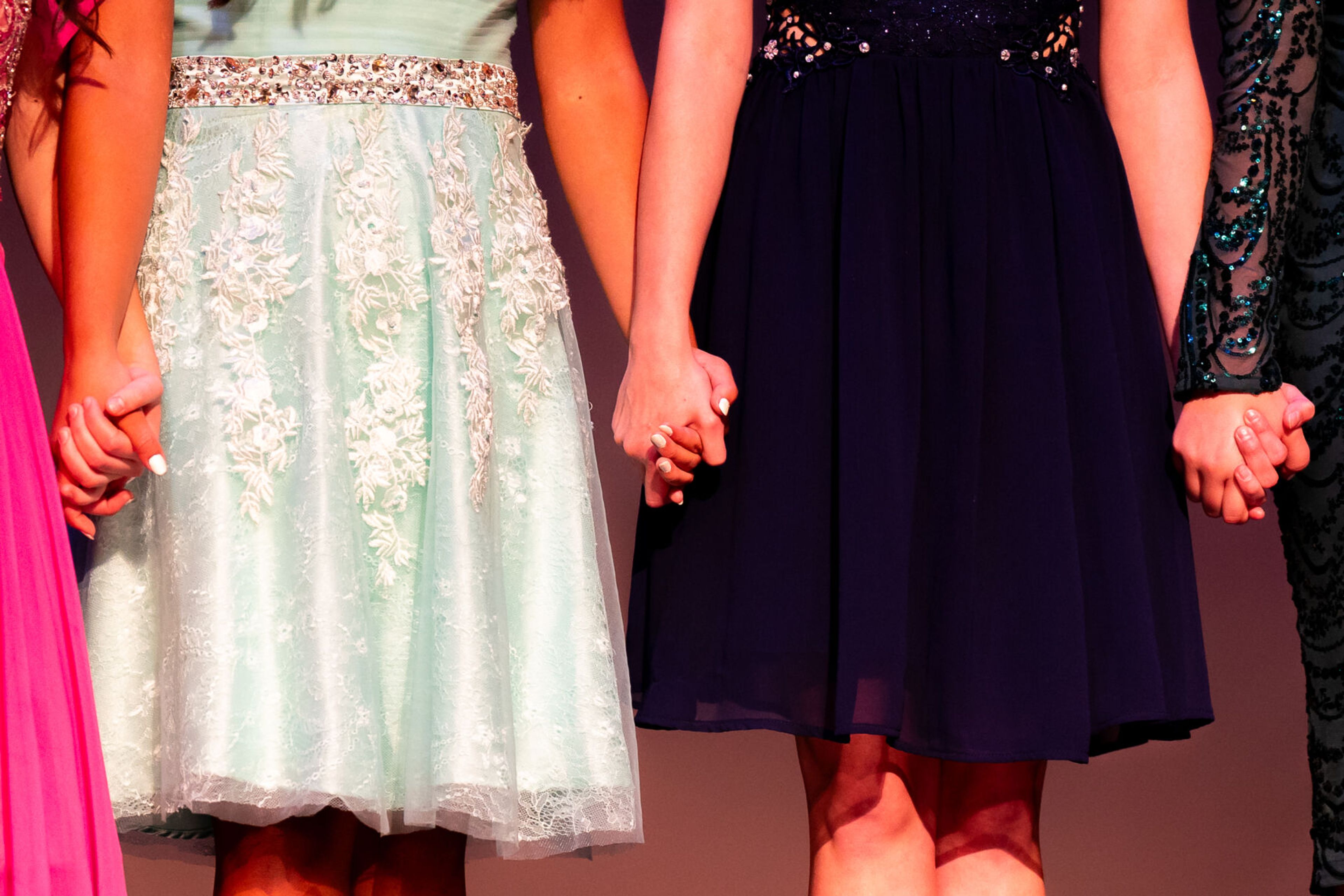 Washington Distinguished Young Woman competitors hold hands as they wait for the winner to be announced on Saturday at Daggy Hall in Pullman.