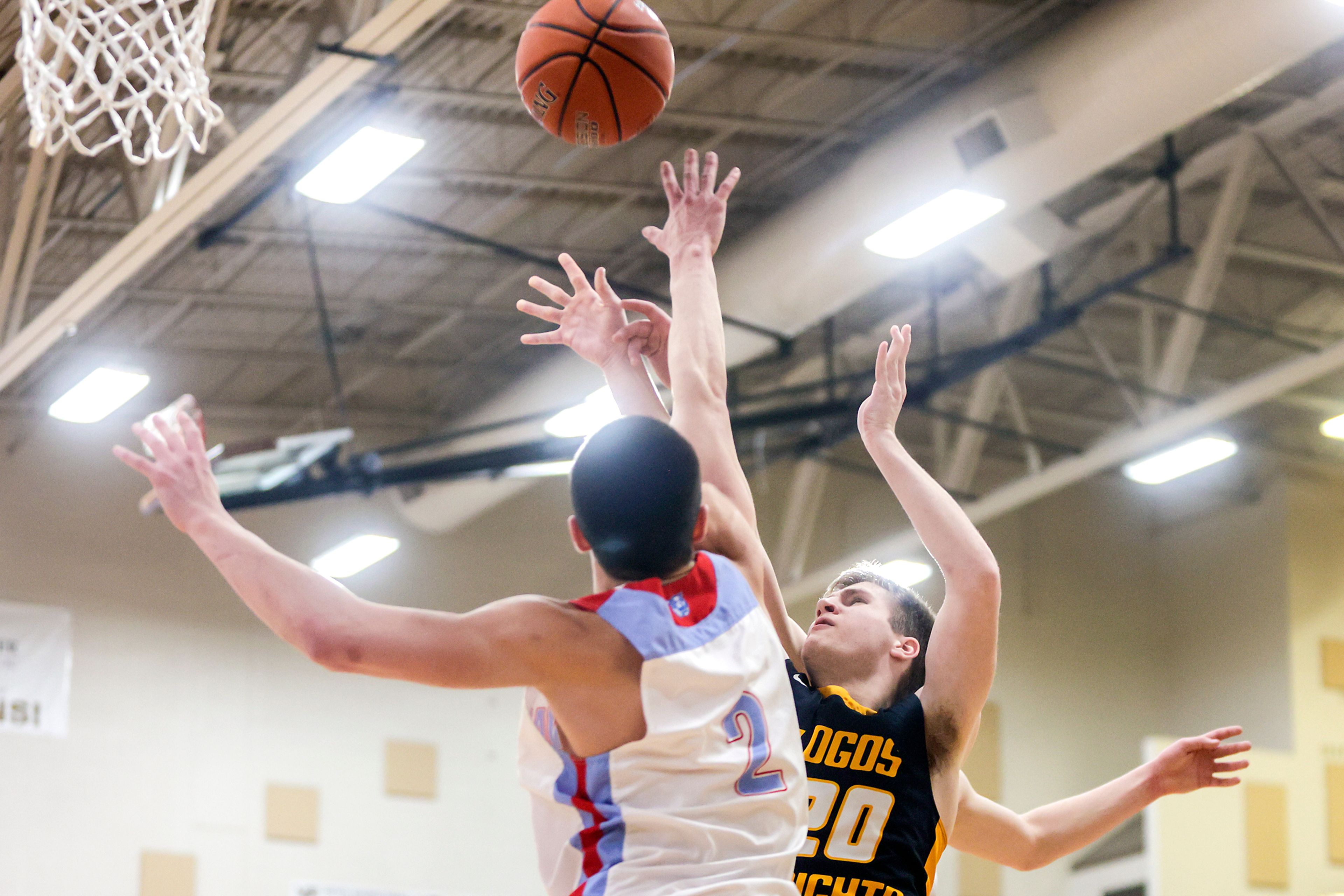 Logos’ Kenny Kline shoots the ball as Lapwai guard Titus Yearout defends during an Idaho state tournament game last season at Vallivue High School in Caldwell. Idaho high school basketball teams will use a shot clock at state tournaments starting in the 2023-24 season.