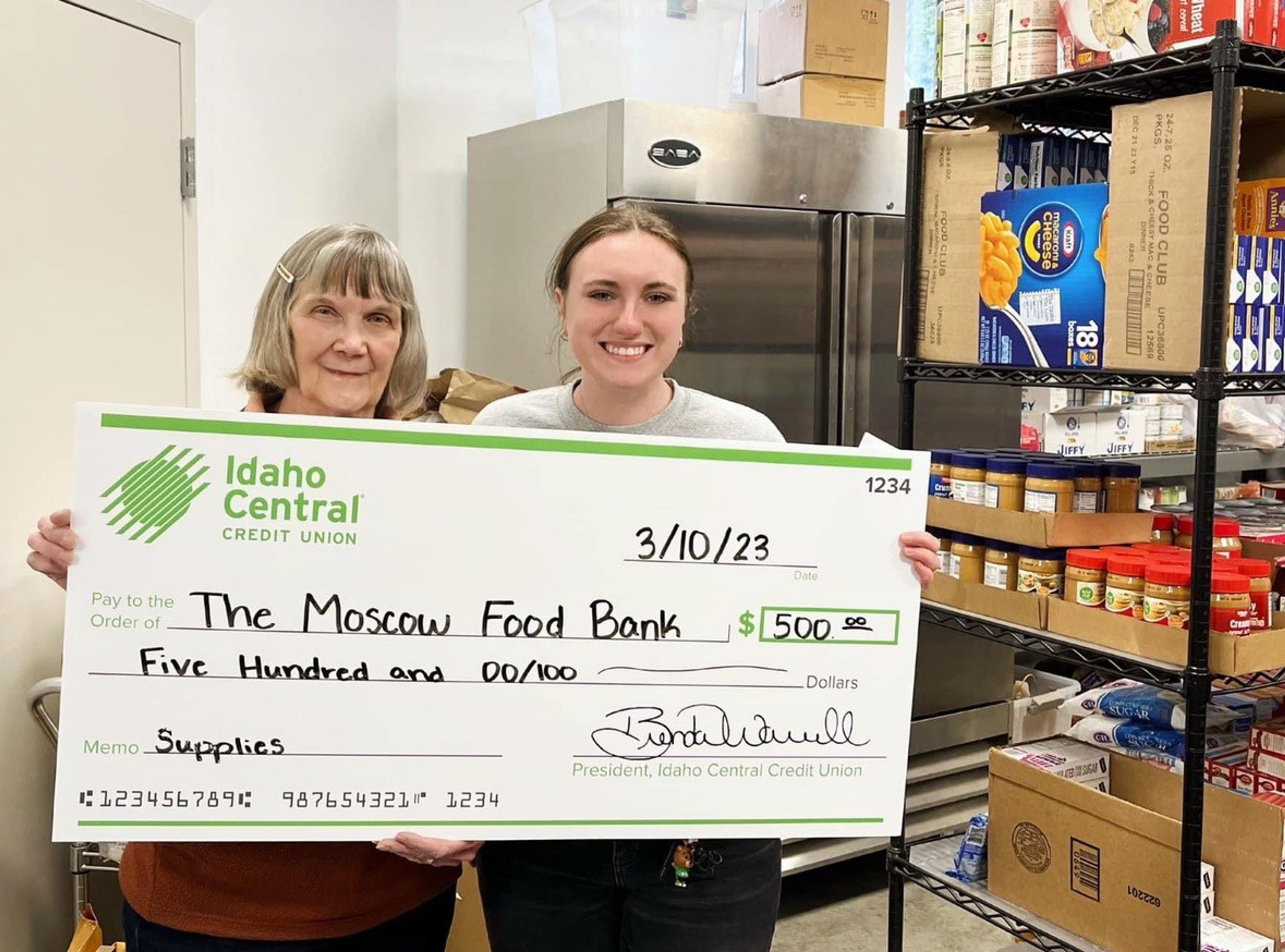 Moscow Food Bank Director Linda Nickels and an Idaho Central Credit Union representative pose for a photo with a check for the Moscow food bank.