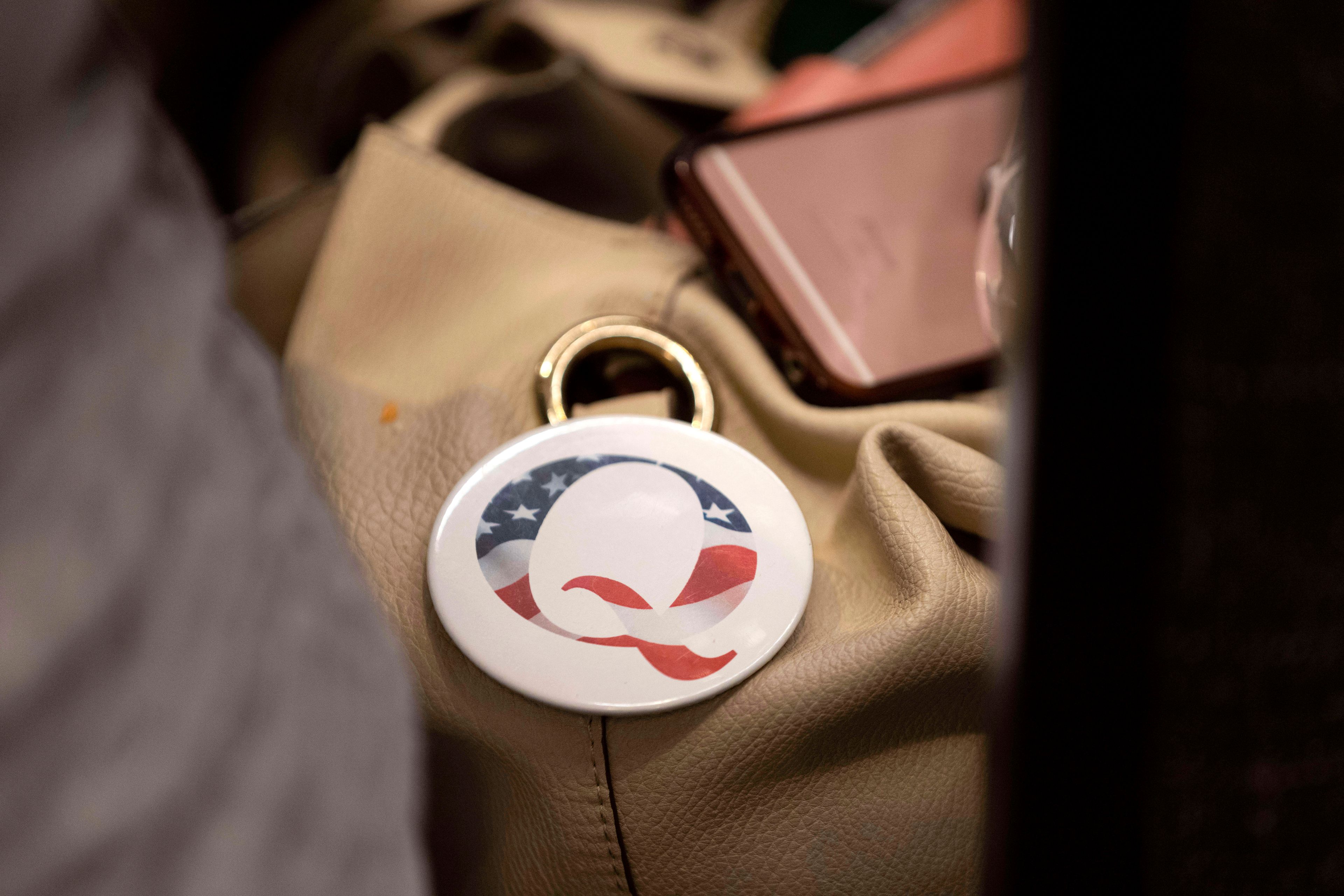 FILE - A QAnon conspiracy theory button sits affixed to the purse of an attendee of the Nebraska Election Integrity Forum on Saturday, Aug. 27, 2022, in Omaha, Neb.