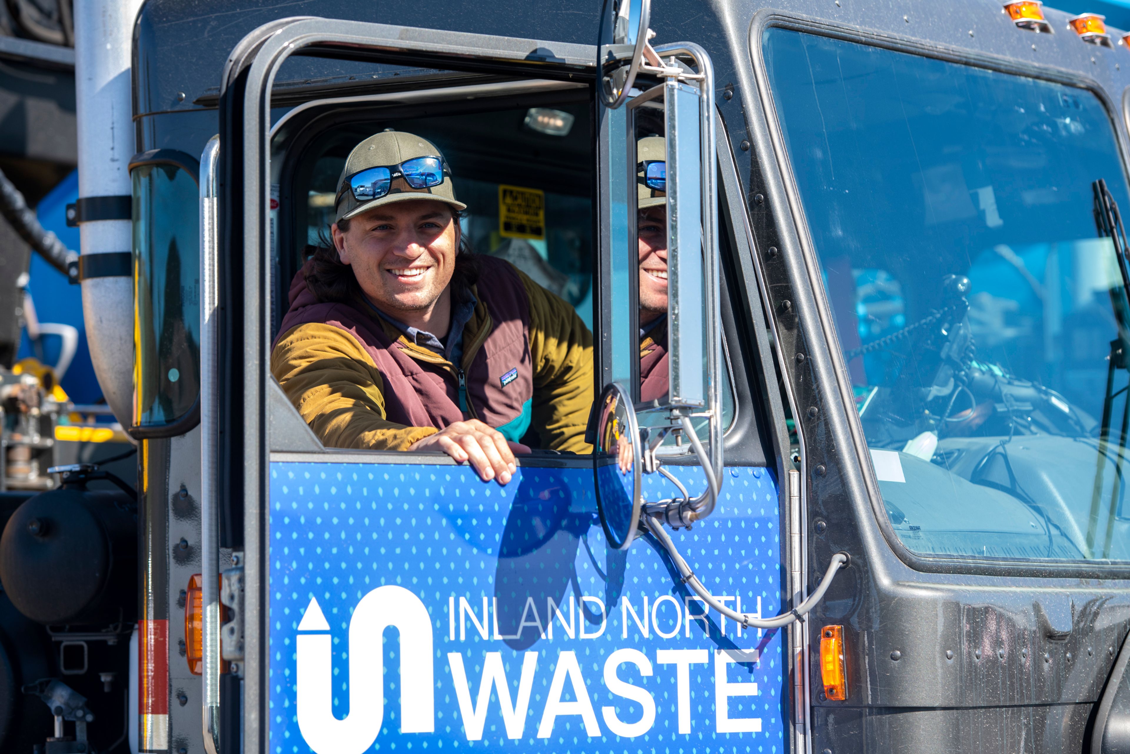 CEO Brandon Steely-Johnson hops in drivers seat of the newly wrapped Inland North Waste truck to move its location in the parking lot.