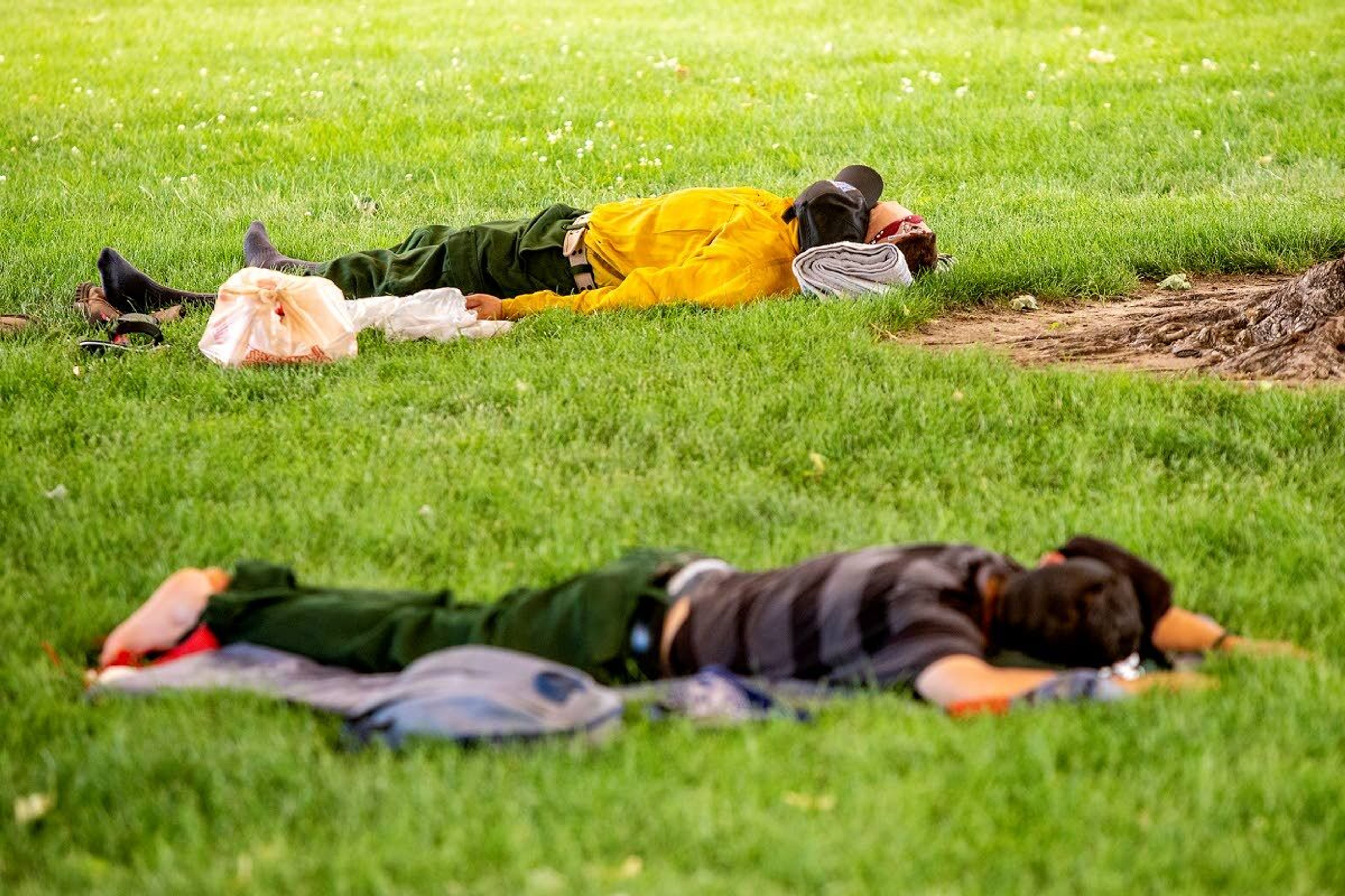 Firefighters sleep in the grass at Chief Looking Glass Park in Asotin on Saturday.